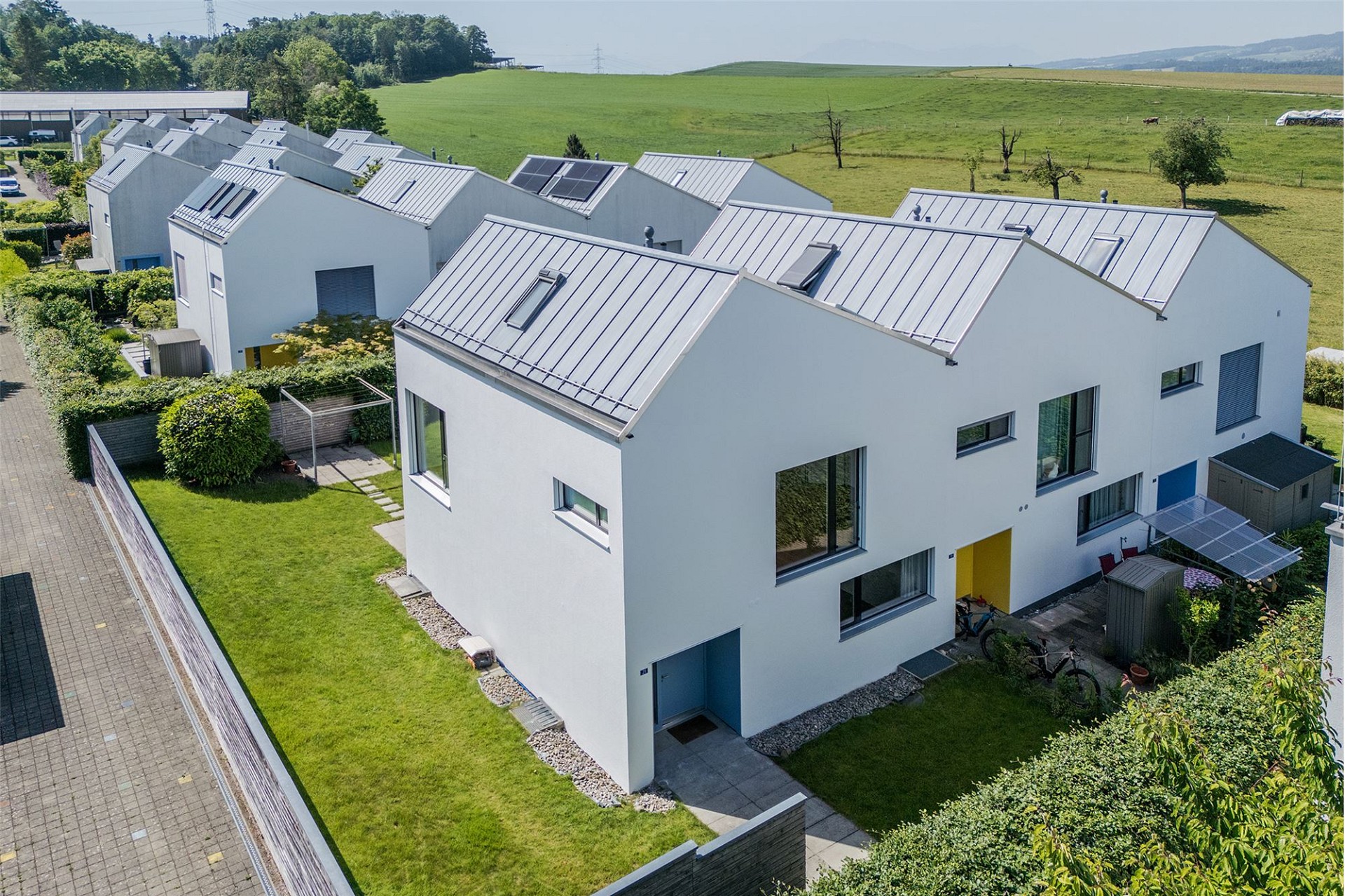 Moderne Reihenhäuser mit Satteldächern und Gartenanlagen