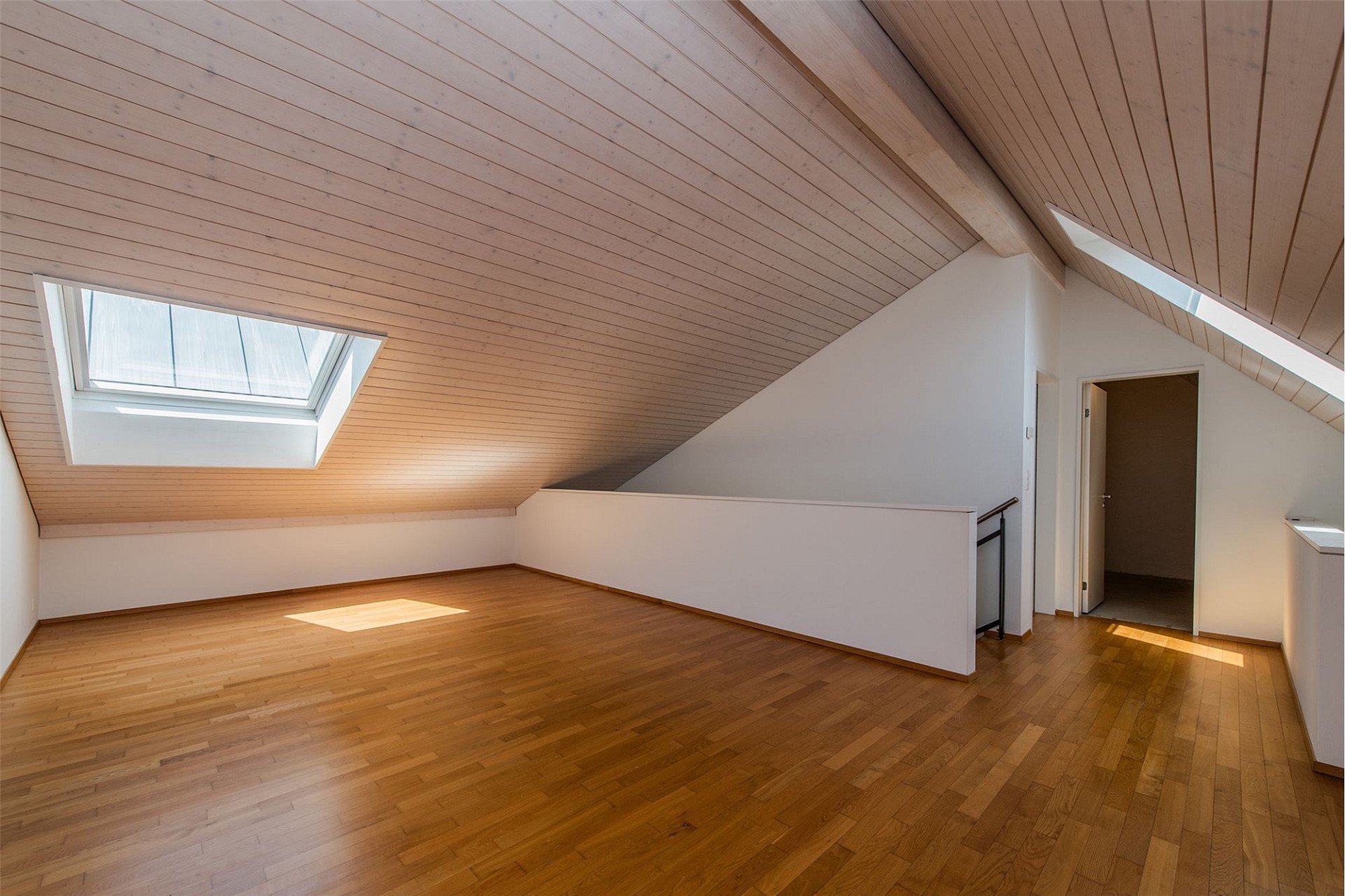 Heller Dachgeschossraum mit Holzdecke und Dachfenster