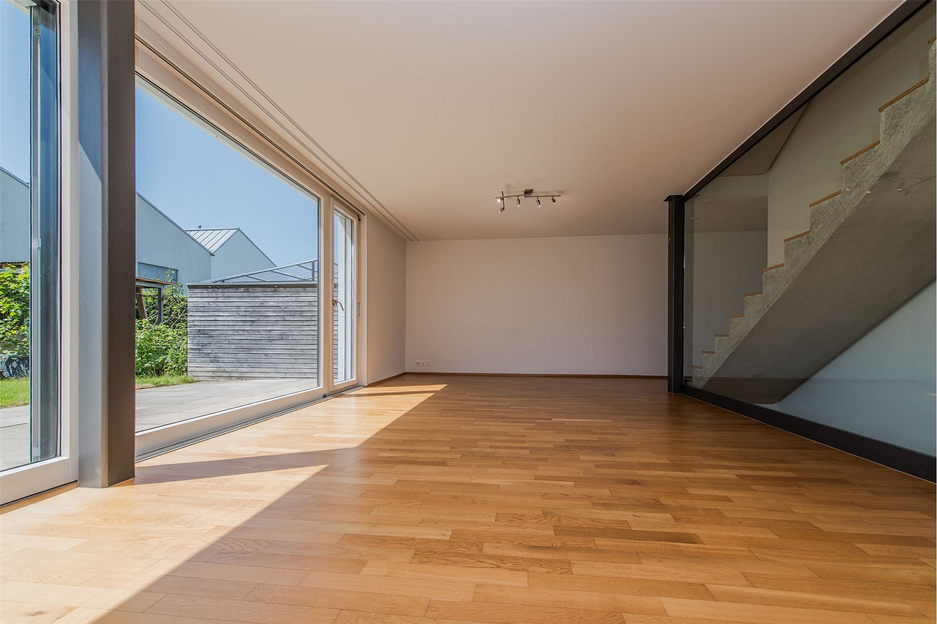 Heller Wohnraum mit großer Glasfront und Holzfußboden