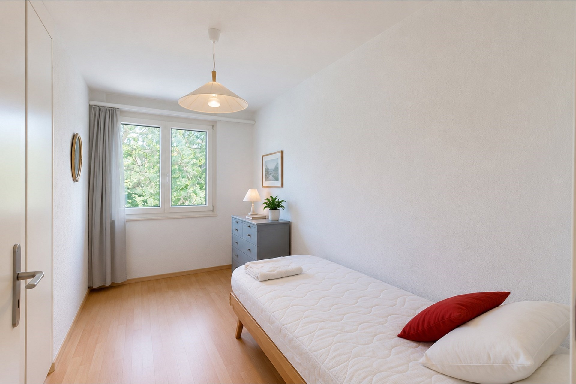 Helles Einzelzimmer mit Bett und Fenster