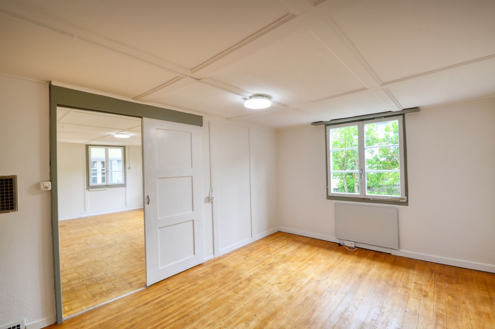 Heller leerer Wohnraum mit Schiebetür und Fenster