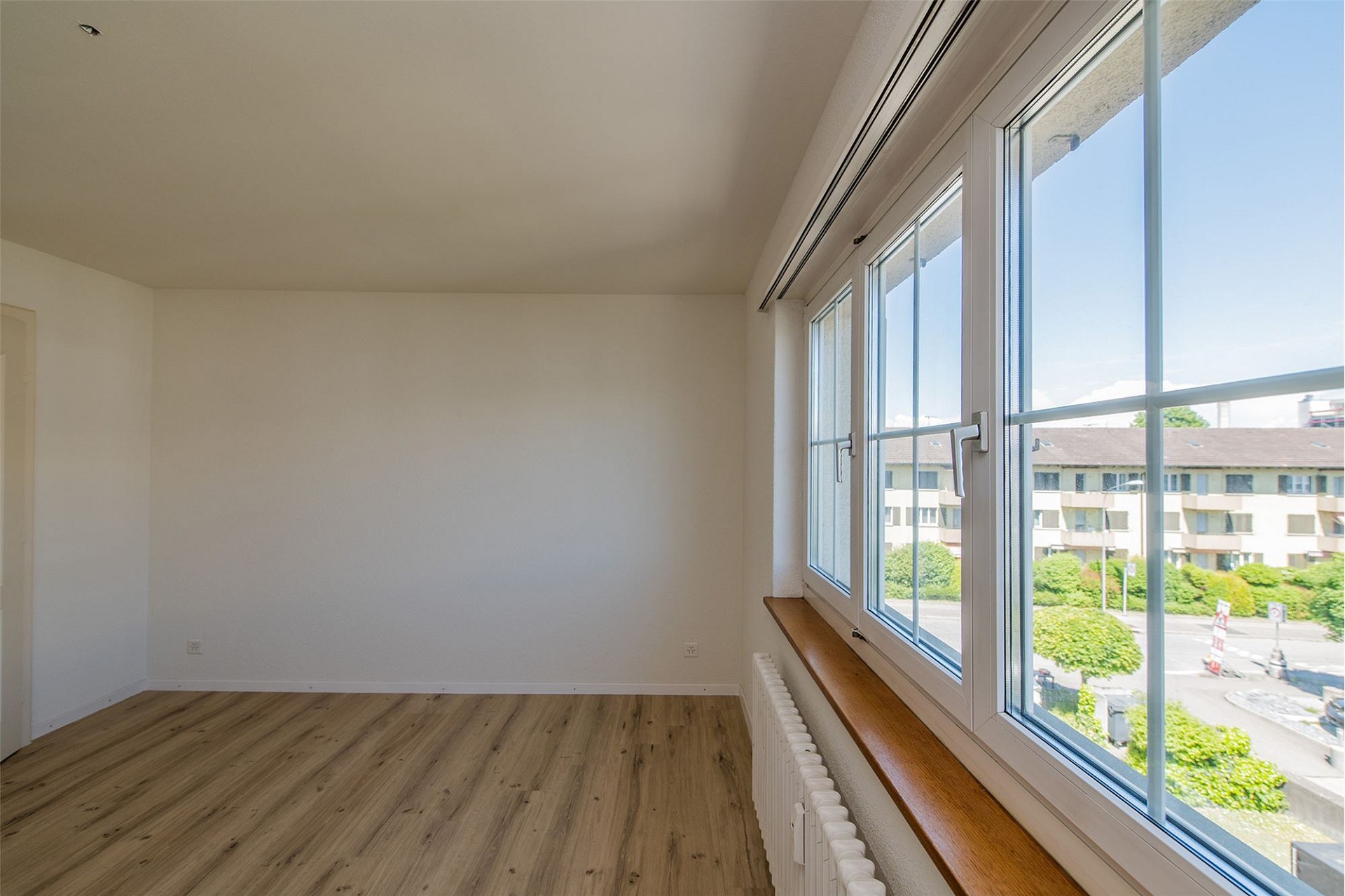 Heller leerer Raum mit großem Fenster und Ausblick
