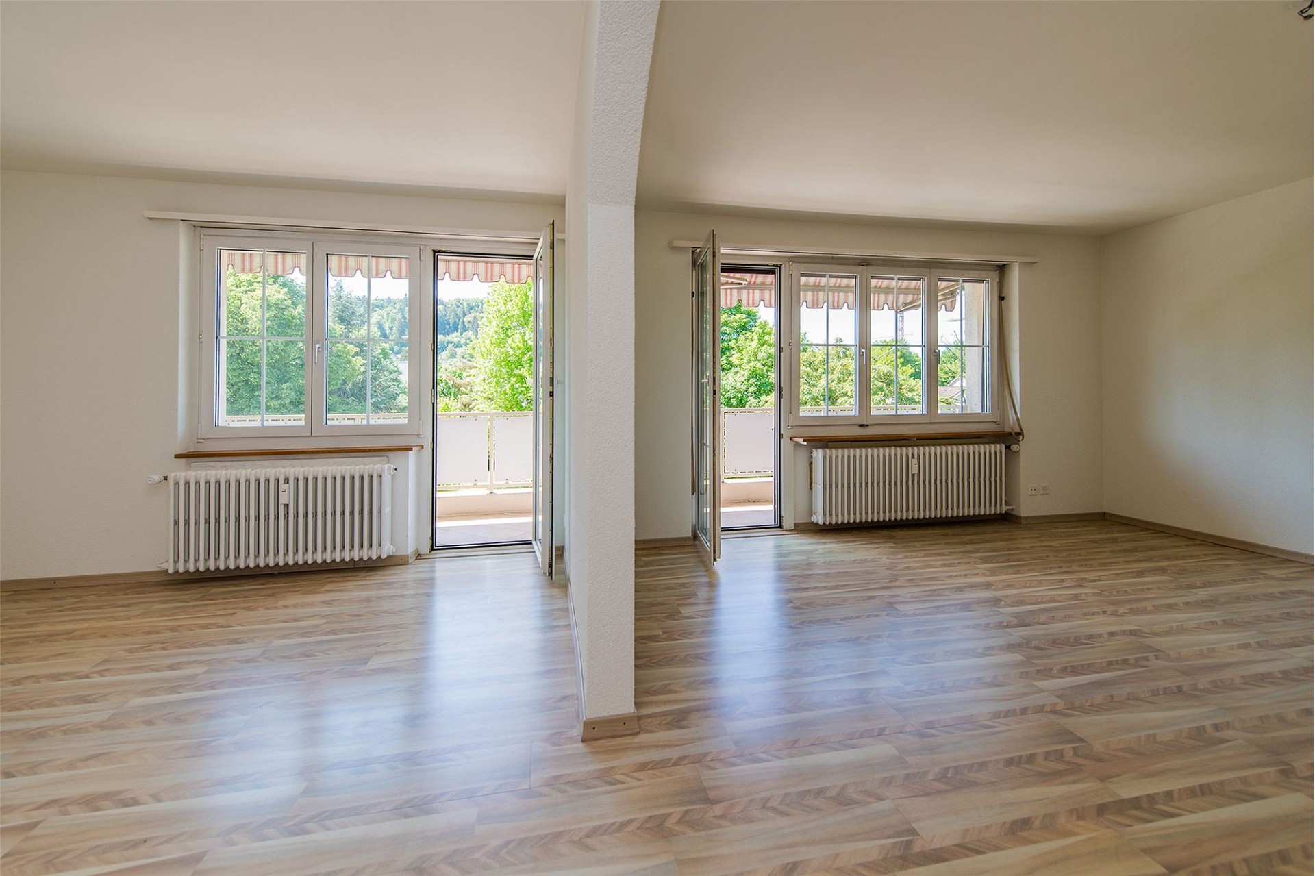 Heller leerer Wohnraum mit Balkonzugang