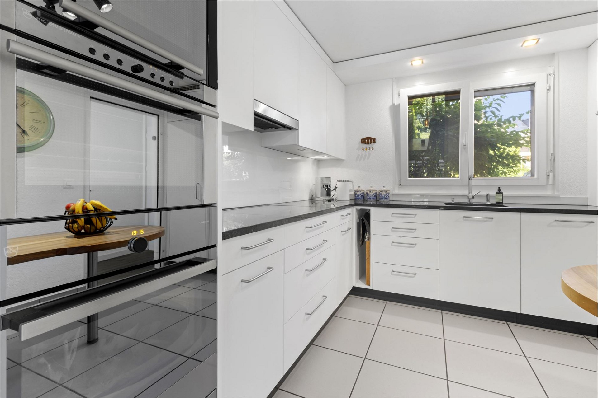 Moderne weiße Küche mit großem Fenster