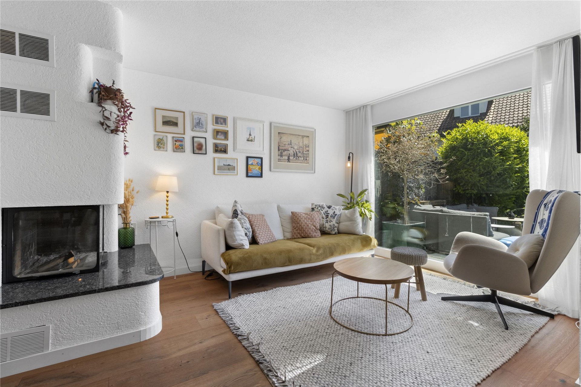 Helles Wohnzimmer mit Kamin und Gartenblick
