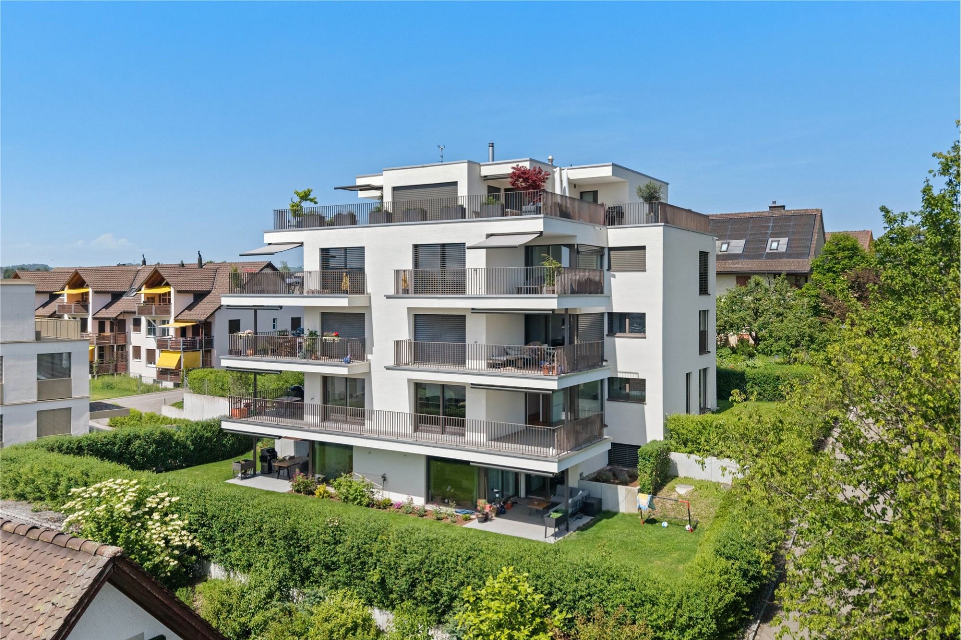 Moderne Mehrfamilienhausanlage mit großzügigen Balkonen und Garten