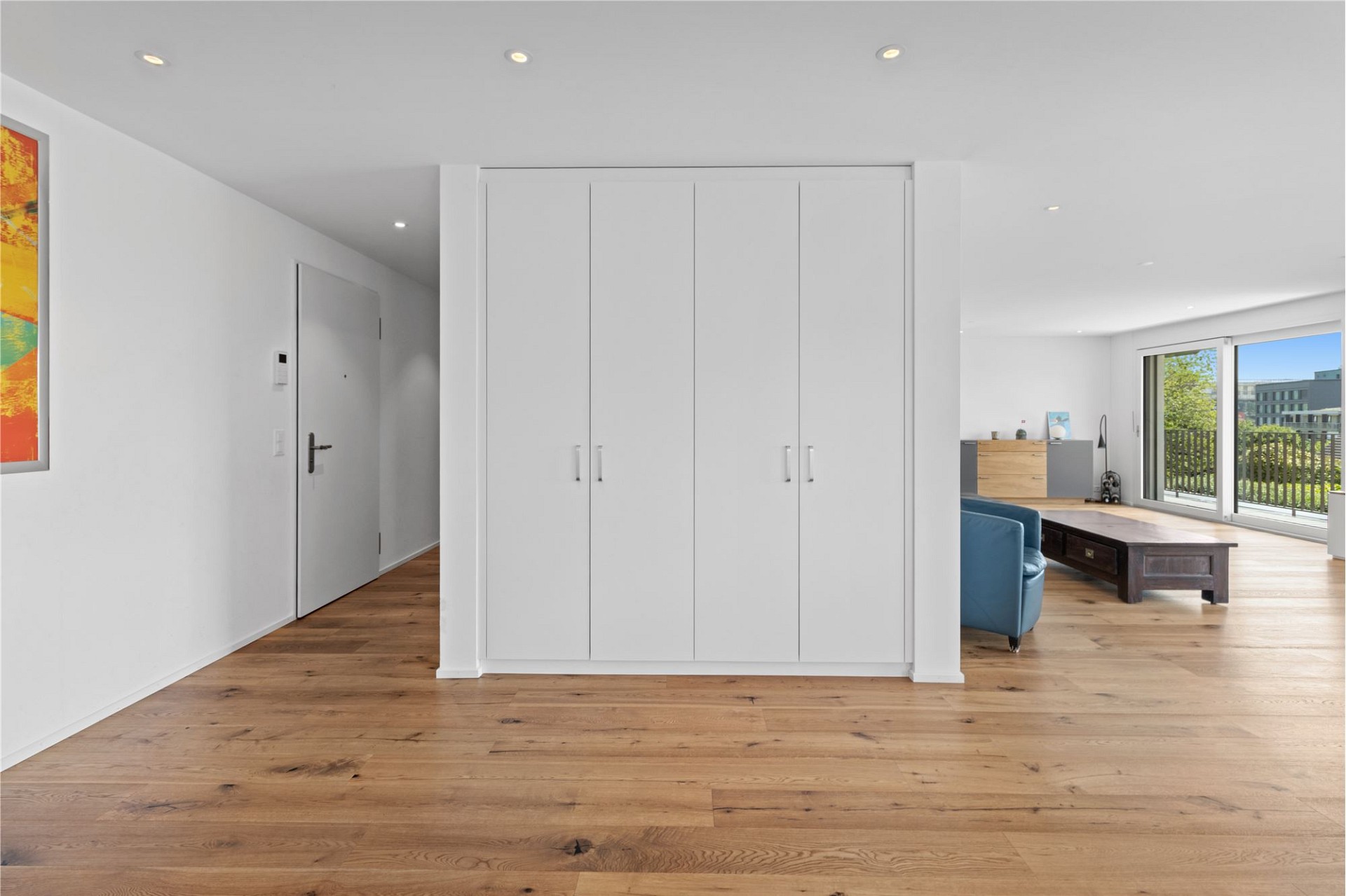 Heller Wohnbereich mit Einbauschrank und Balkonblick