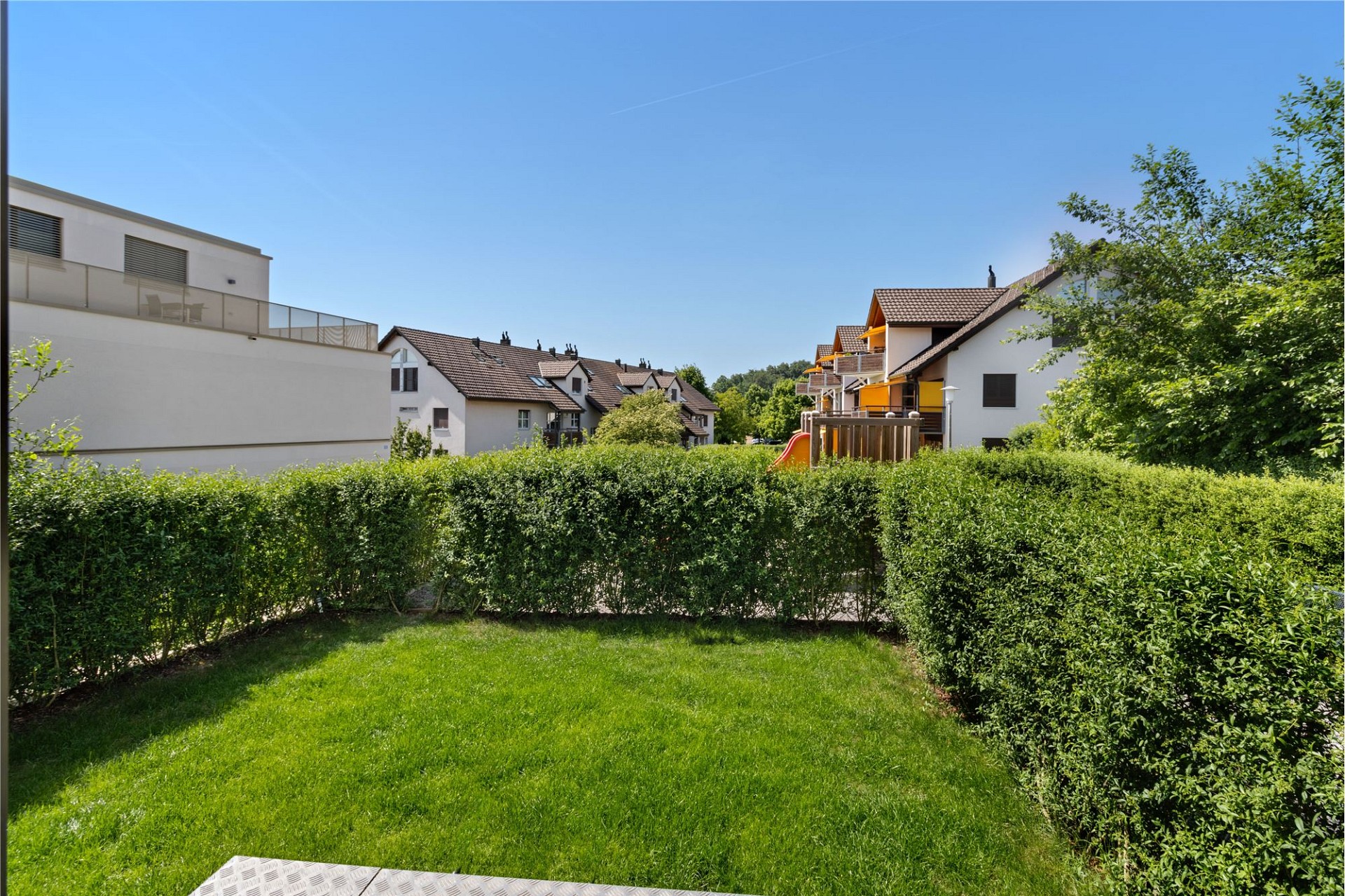 Blick in einen begrünten Innenhof mit Wohnhäusern