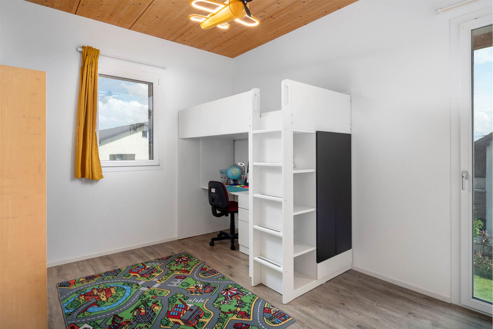 Kinderzimmer mit Hochbett und Schreibtisch