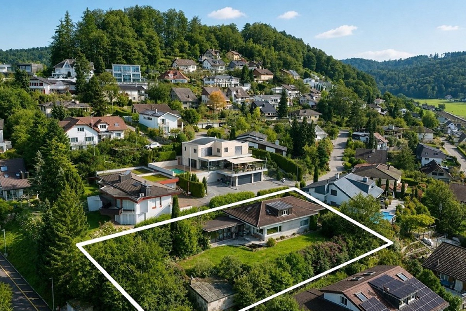 Luftaufnahme eines Grundstücks in einem grünen Wohngebiet
