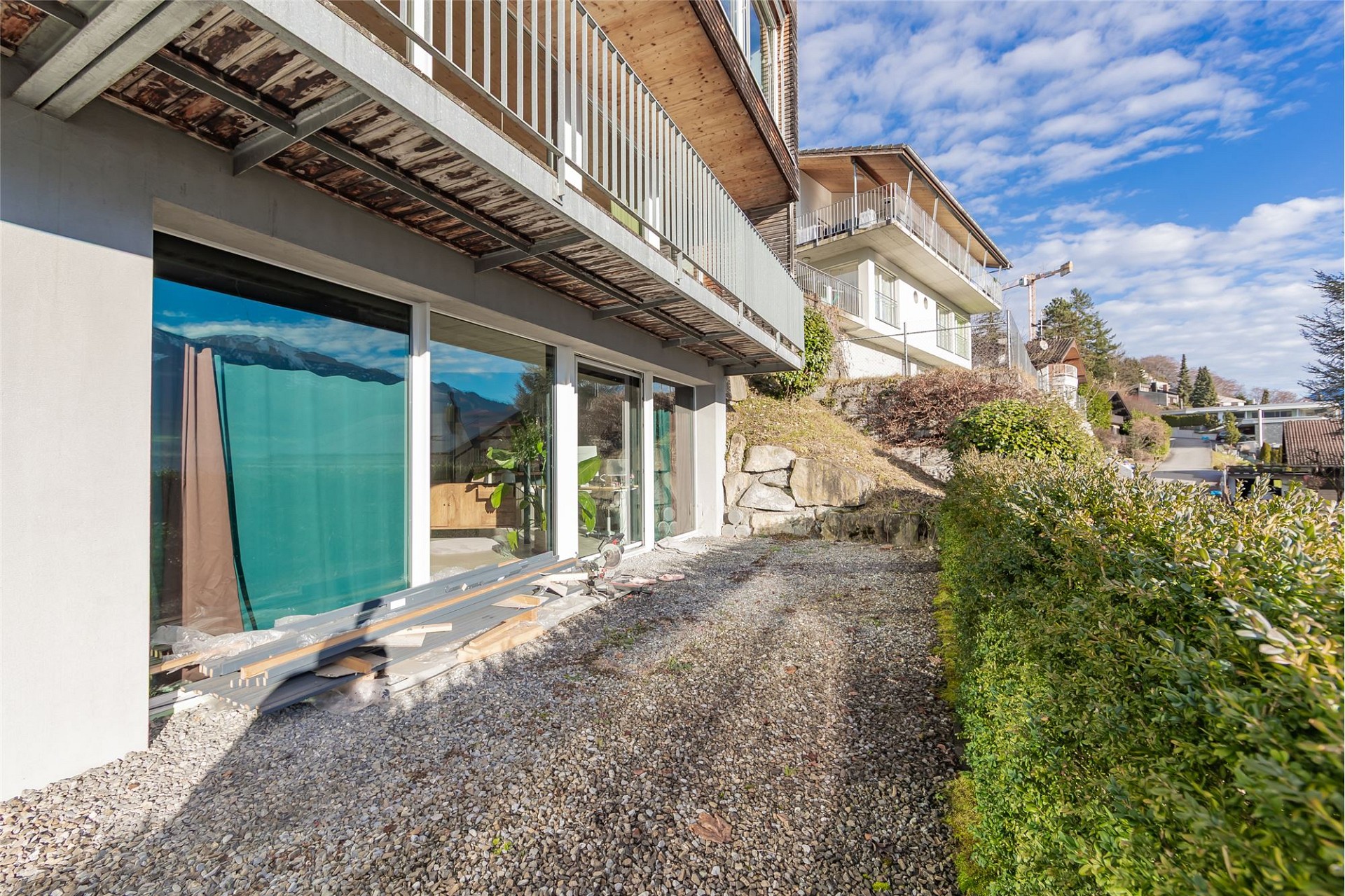 Außenansicht eines modernen Wohngebäudes mit Hanglage und Balkon