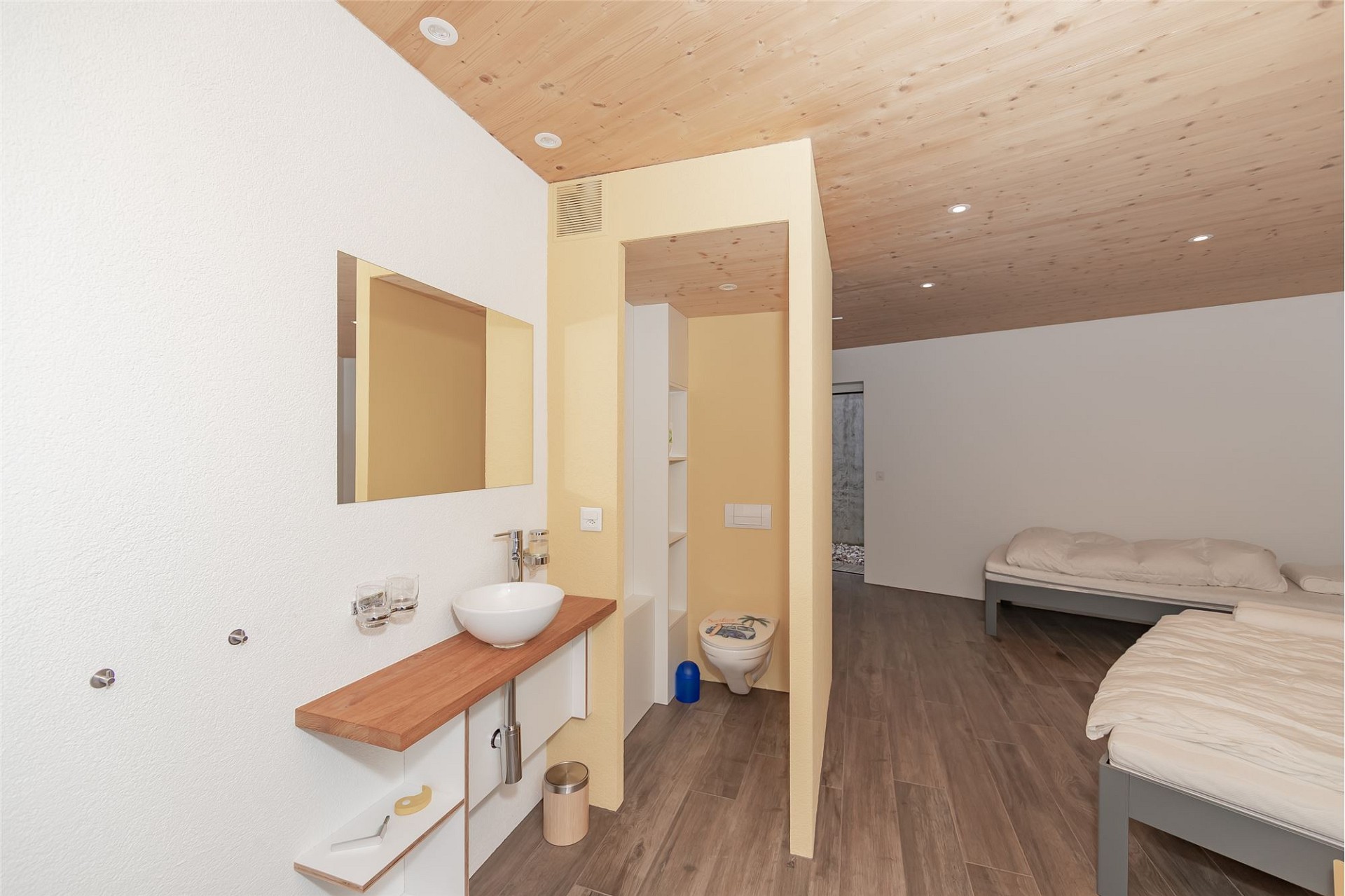 Schlafzimmer mit integriertem Waschbereich und WC
