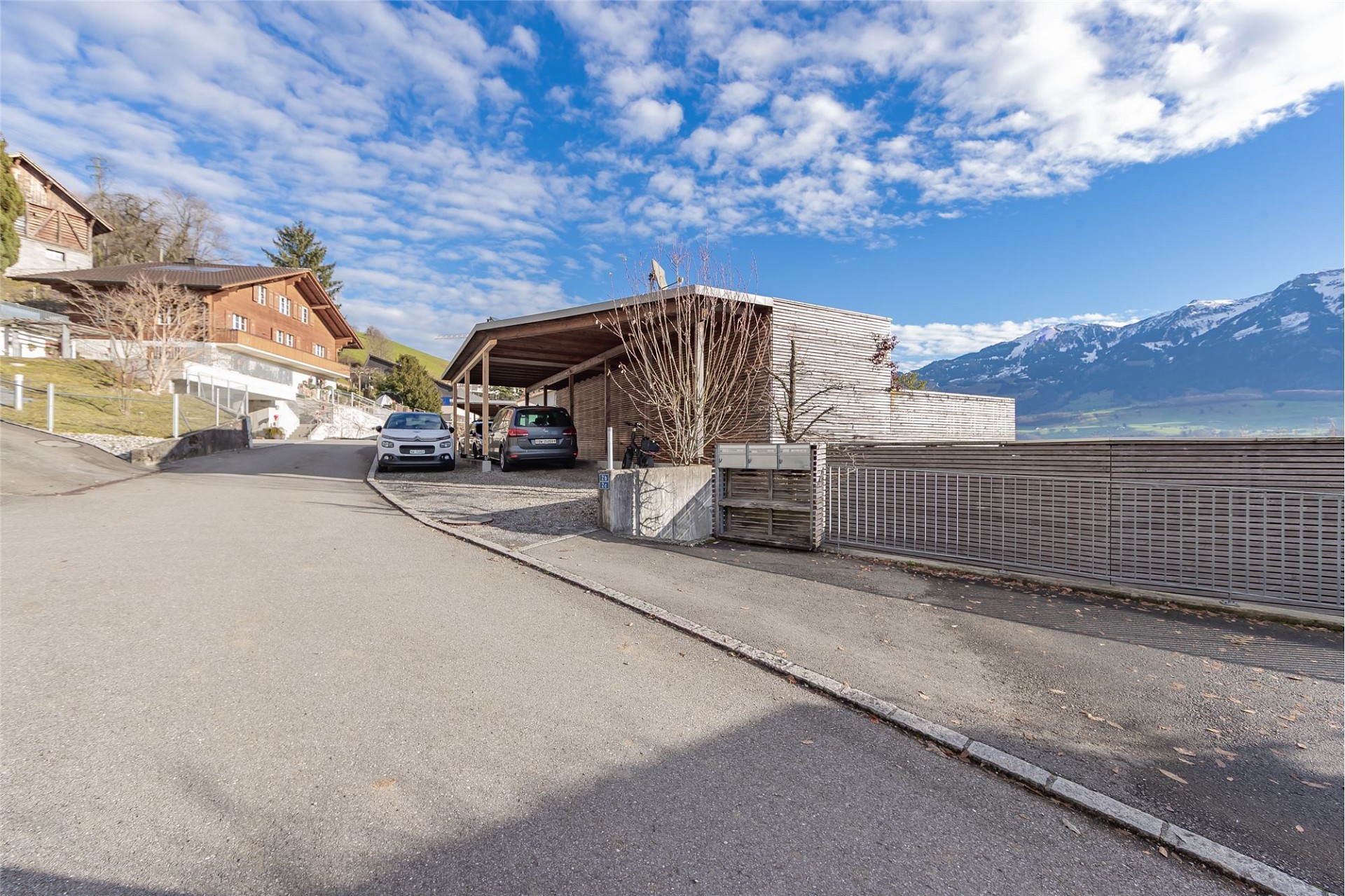 Außenansicht eines modernen Wohnhauses mit Carport und Bergblick