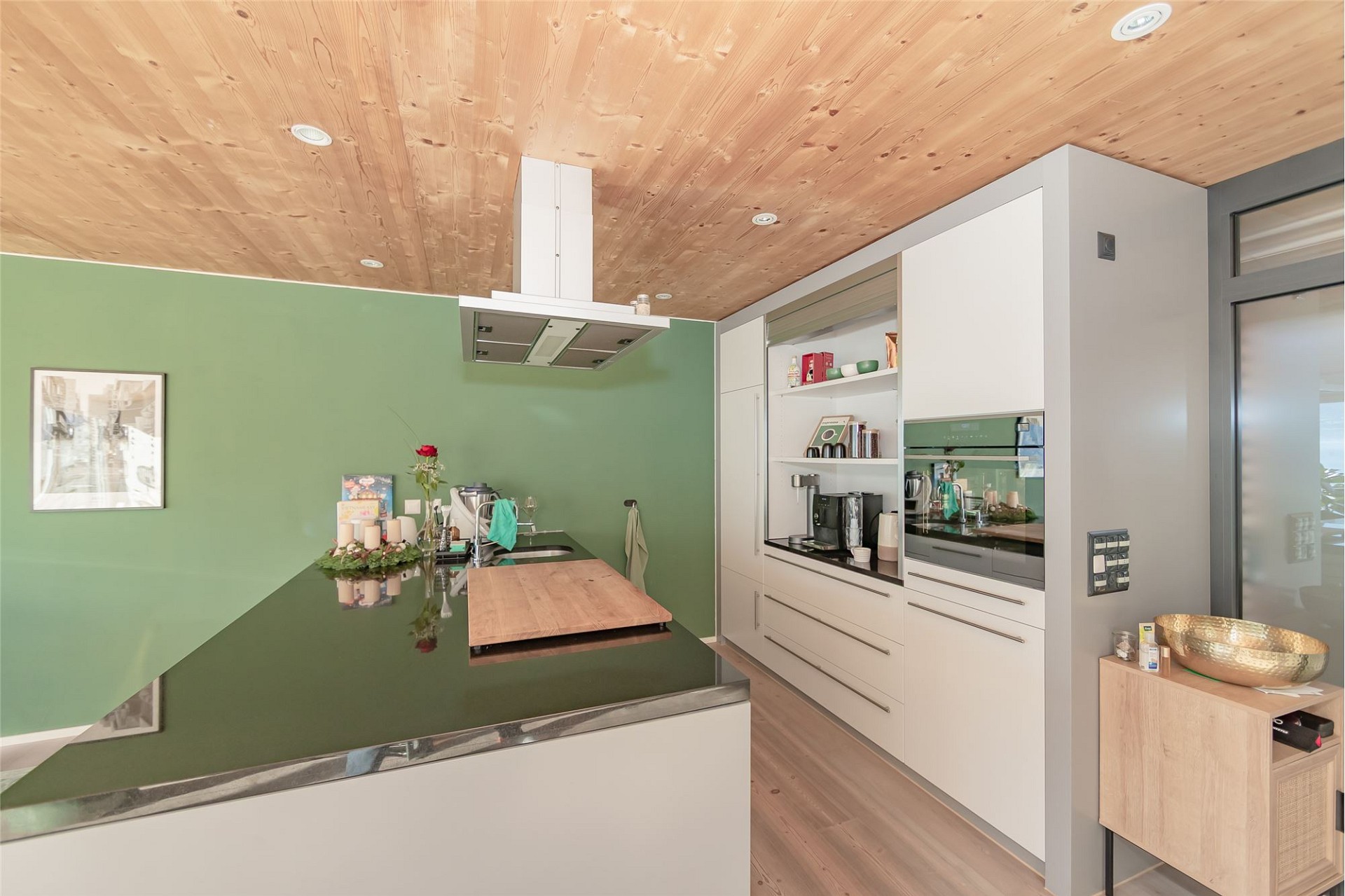 Moderne Küche mit grünem Akzent und Holzdecke