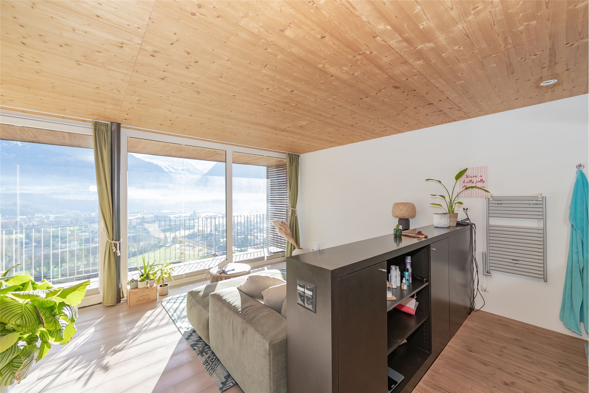 Heller Wohnraum mit Panoramafenster und Blick ins Tal