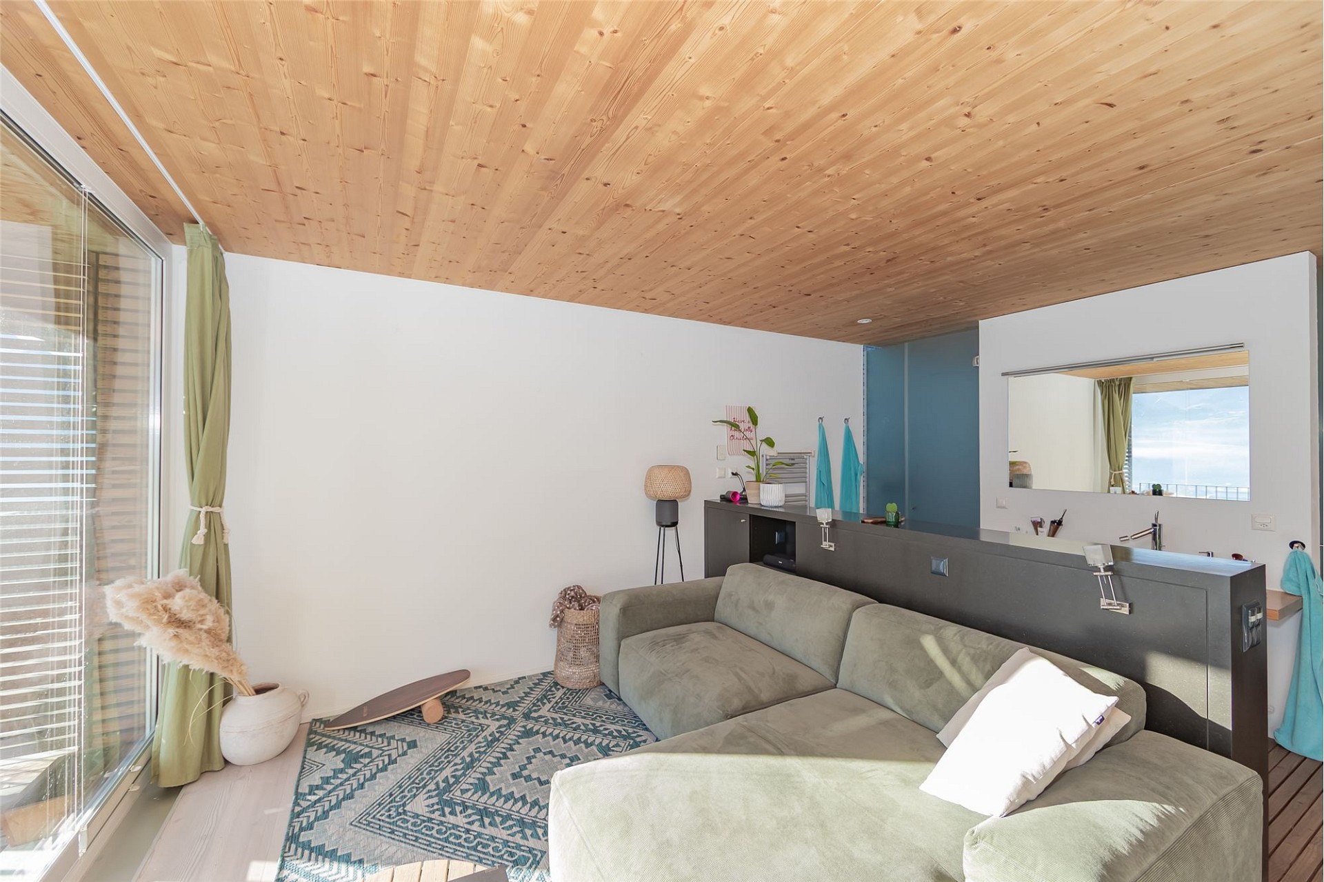 Heller Wohnraum mit Holzdecke und Lounge-Bereich