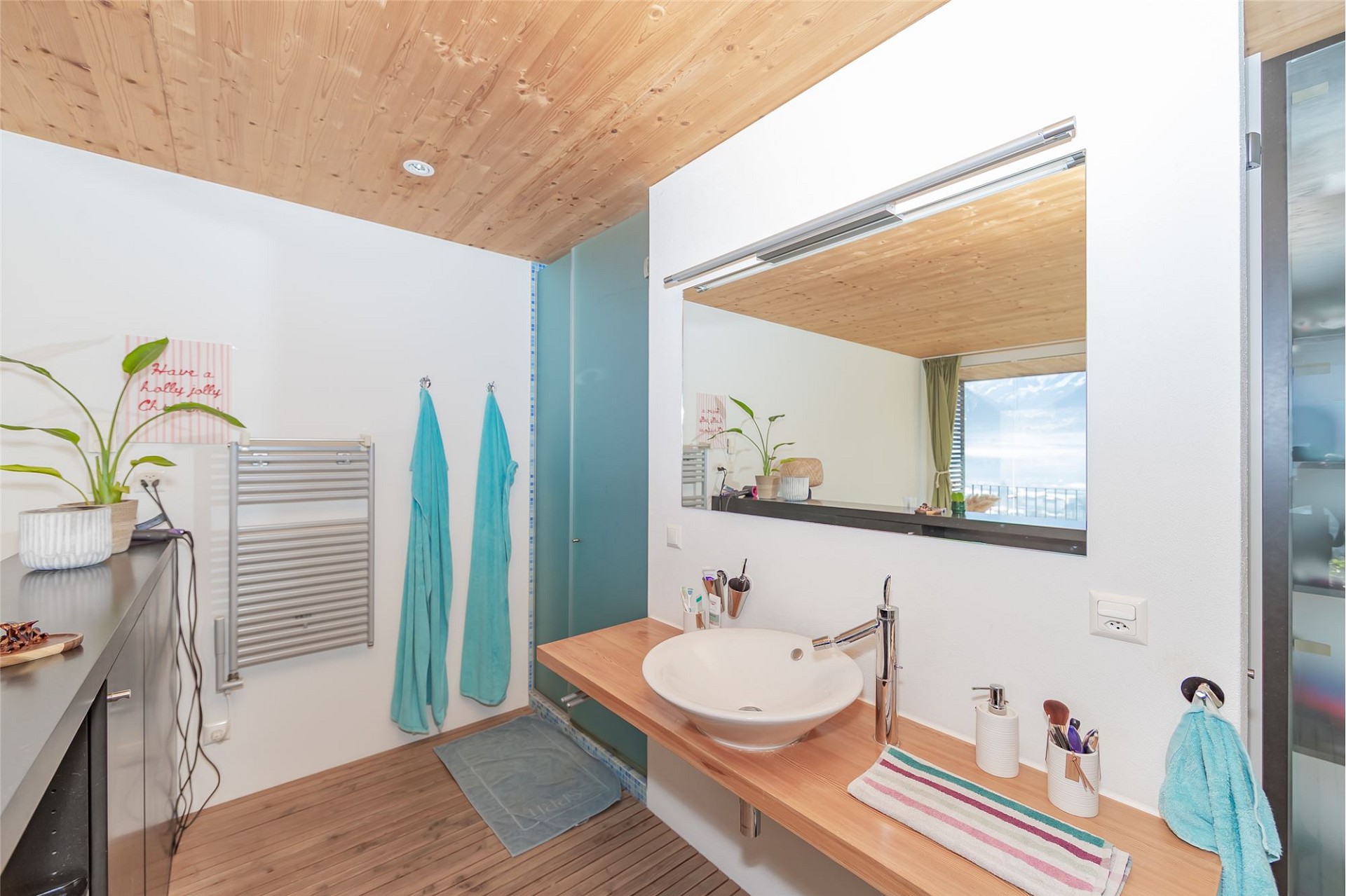 Modernes Badezimmer mit Holzdecke und Blick nach draußen