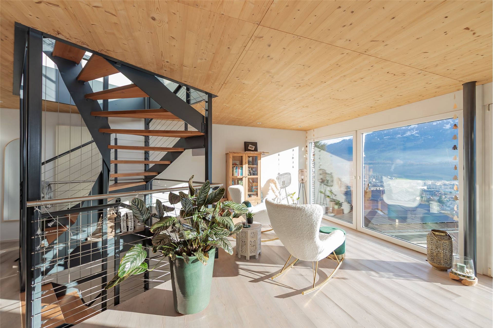 Lichtdurchflutetes Wohnloft mit Treppe und Bergblick
