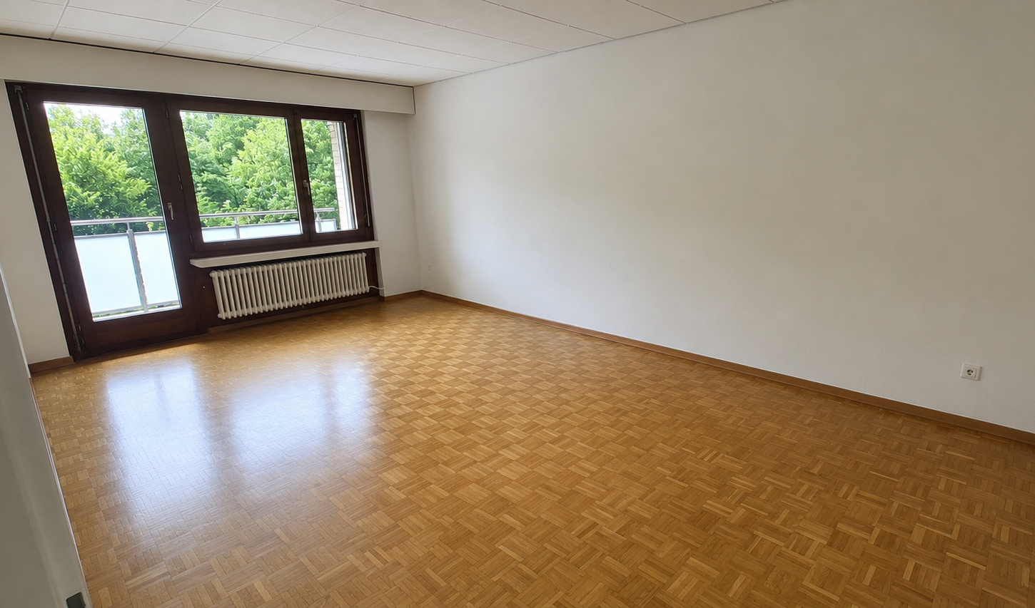 Leerer Wohnraum mit Balkonzugang
