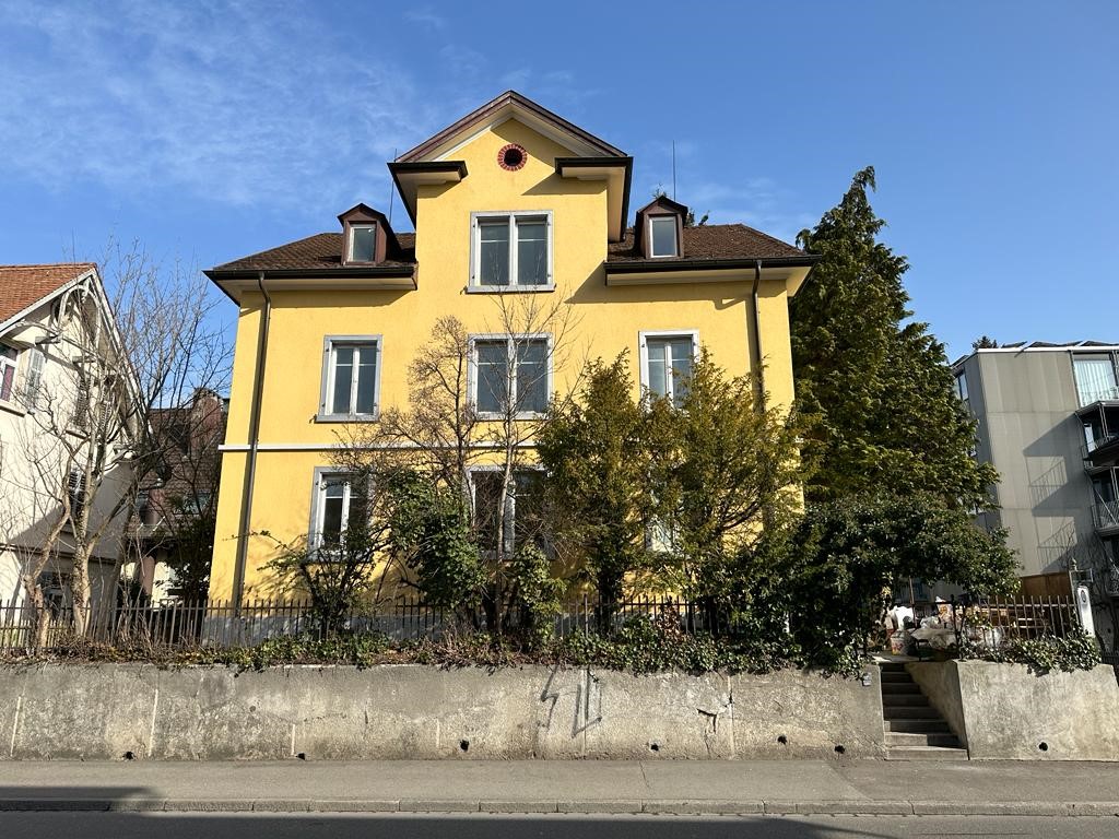Gelbes Mehrfamilienhaus mit Vorgarten