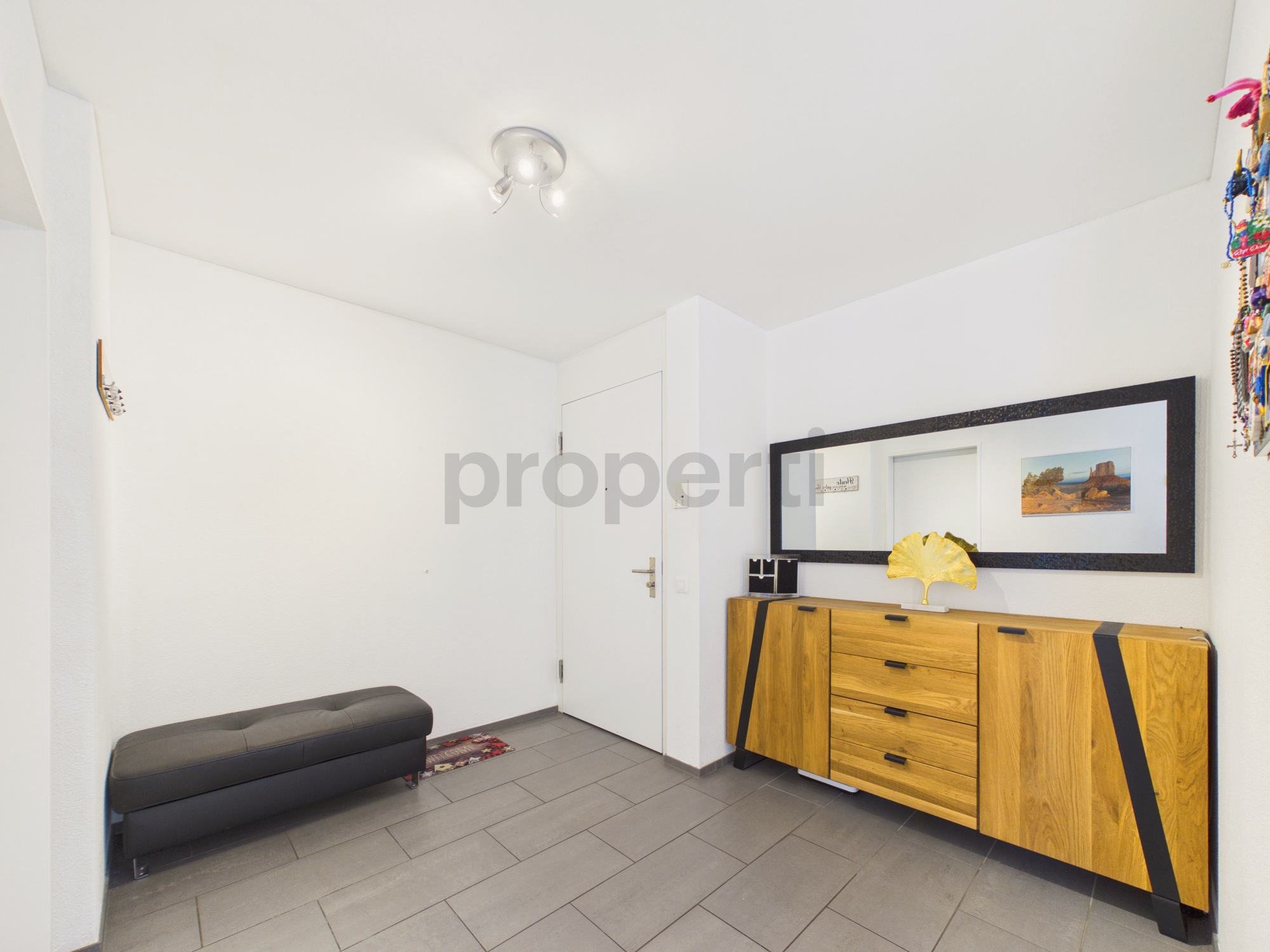 Heller Eingangsbereich mit Sideboard und Spiegel