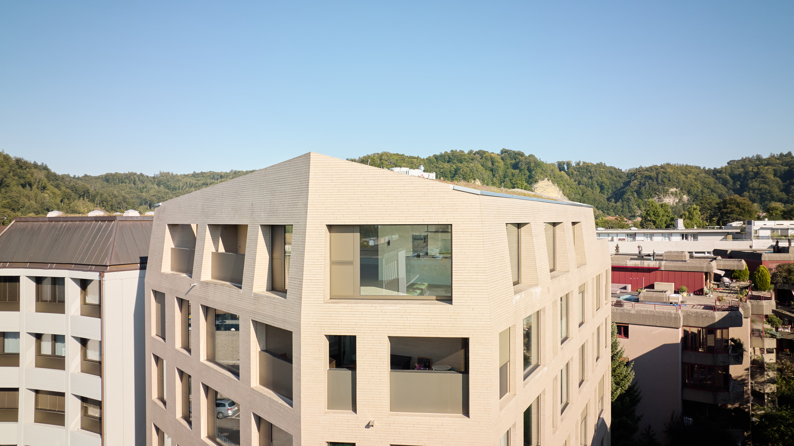 Modernes Gebäude mit Dachterrasse und Bergkulisse