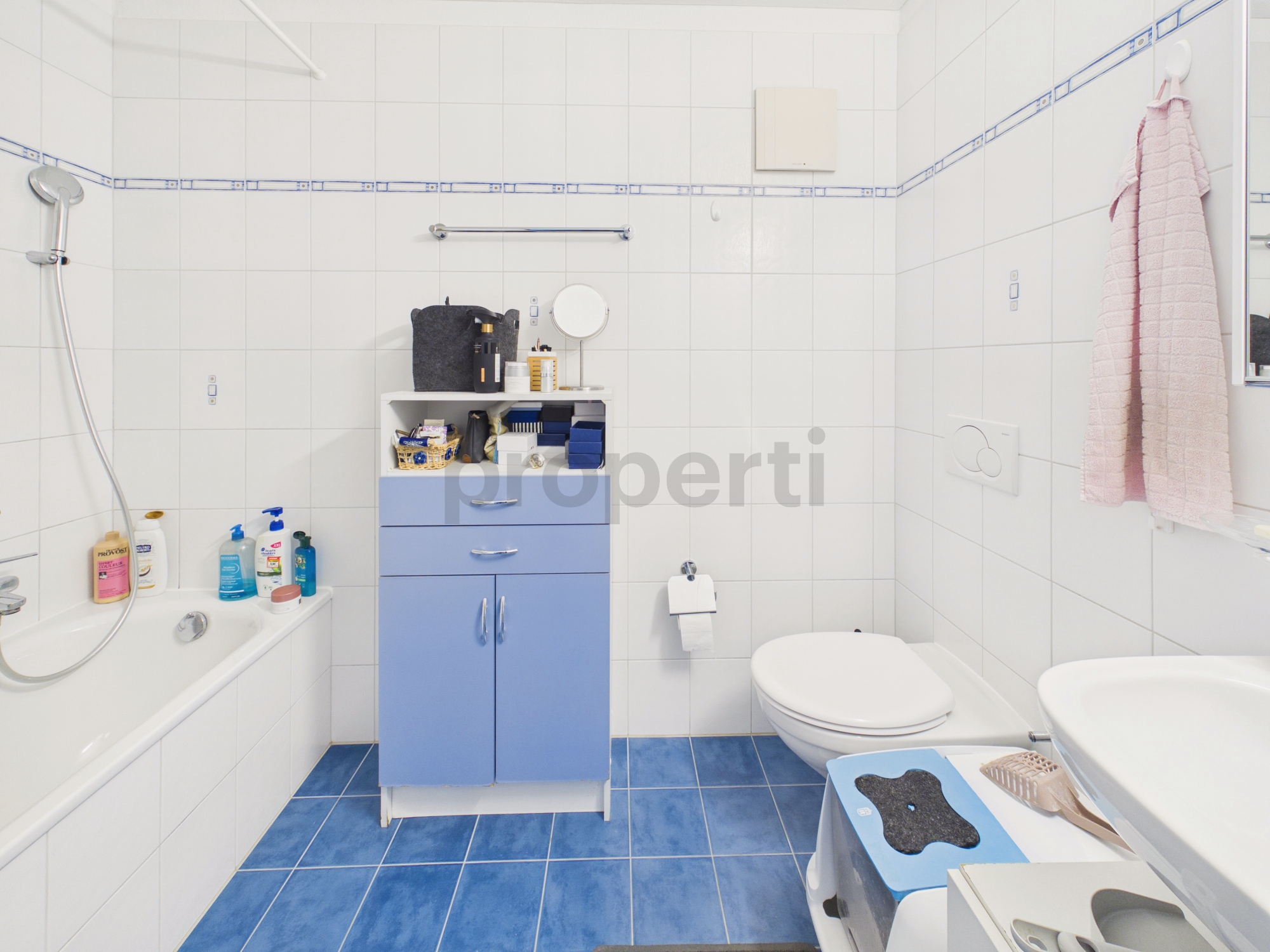 Kleines weißes Badezimmer mit blauen Fliesen