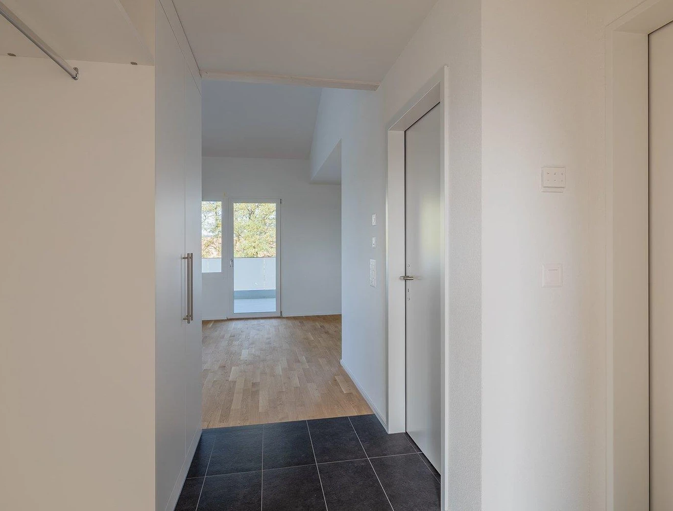Moderner Flur mit Blick in einen hellen Wohnbereich