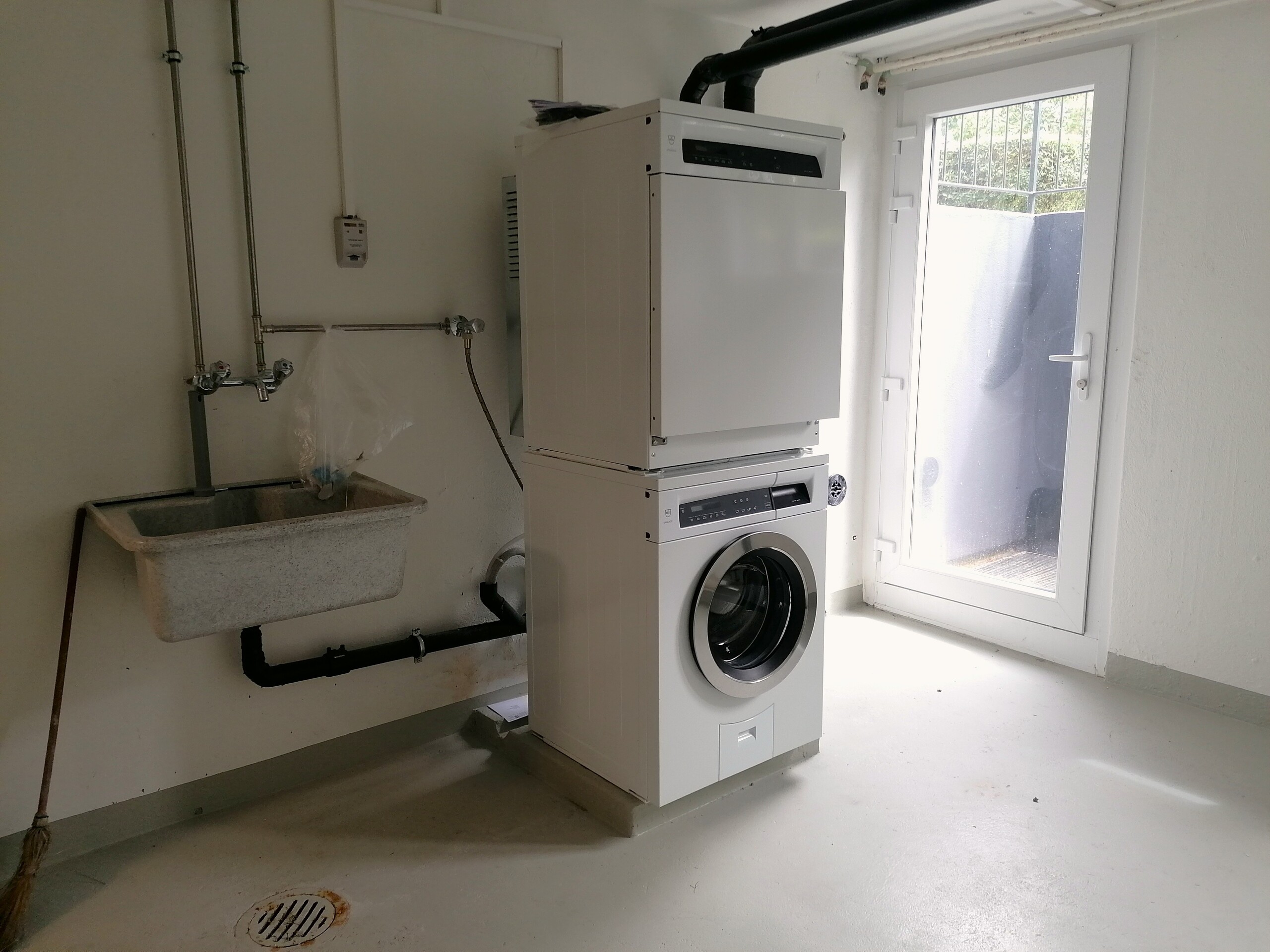 Hauswirtschaftsraum mit Waschmaschine, Trockner und Ausgussbecken