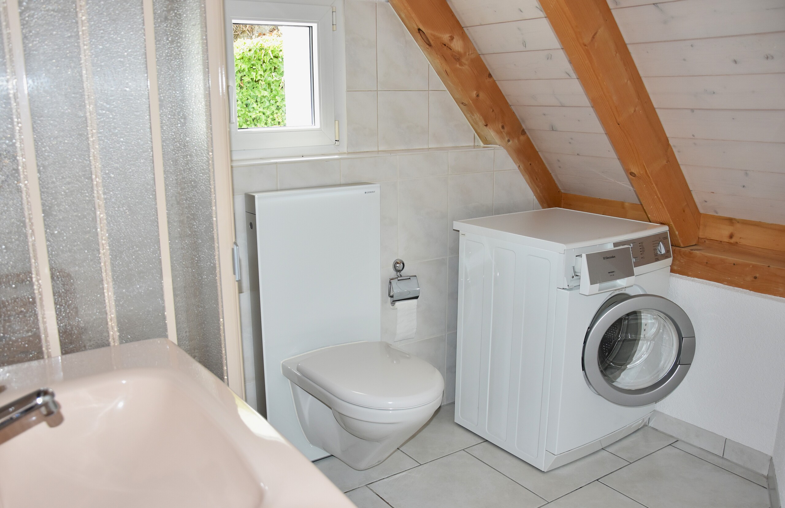 Dachgeschoss-Badezimmer mit WC und Waschmaschine