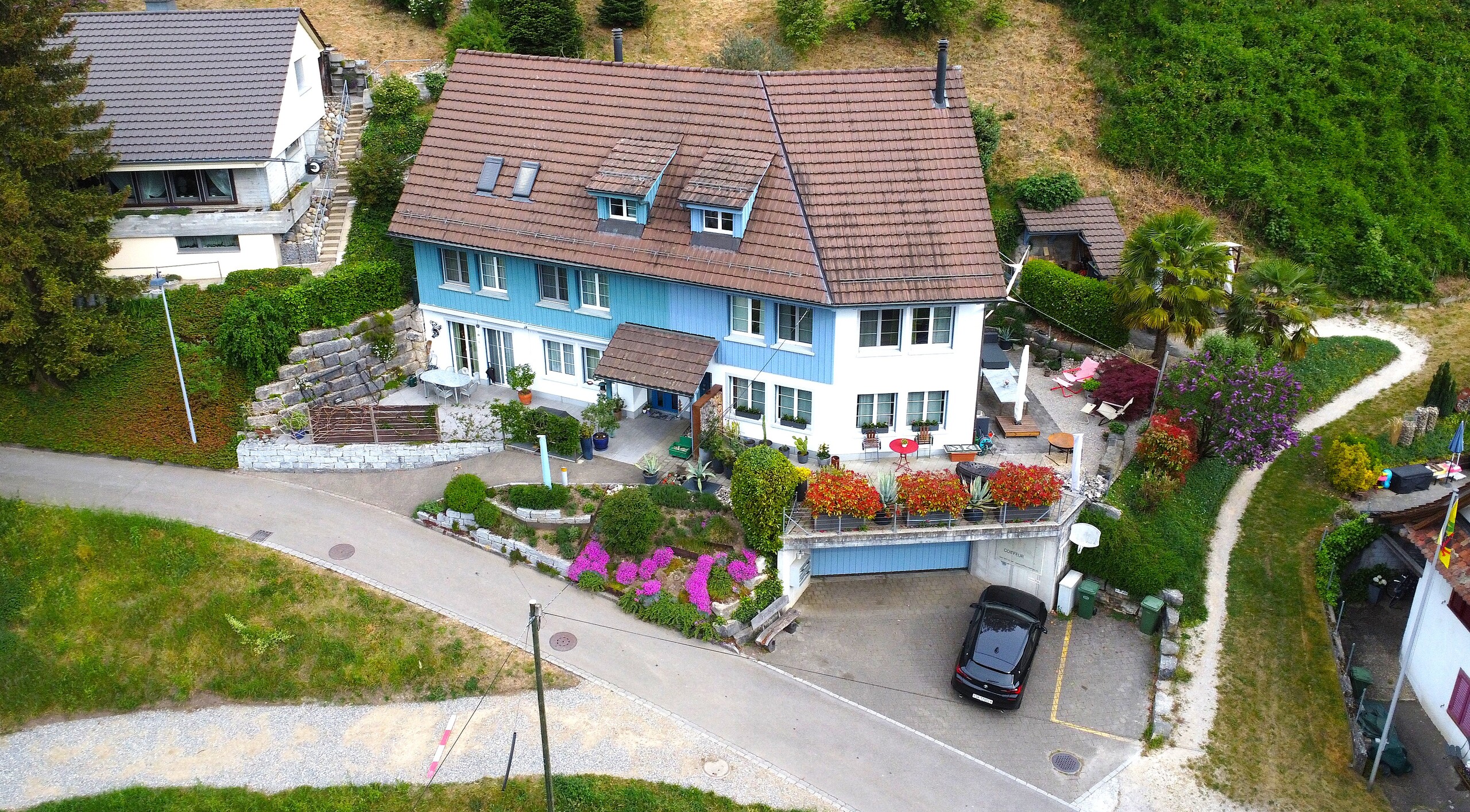 Luftaufnahme eines Einfamilienhauses mit Garten und Garage