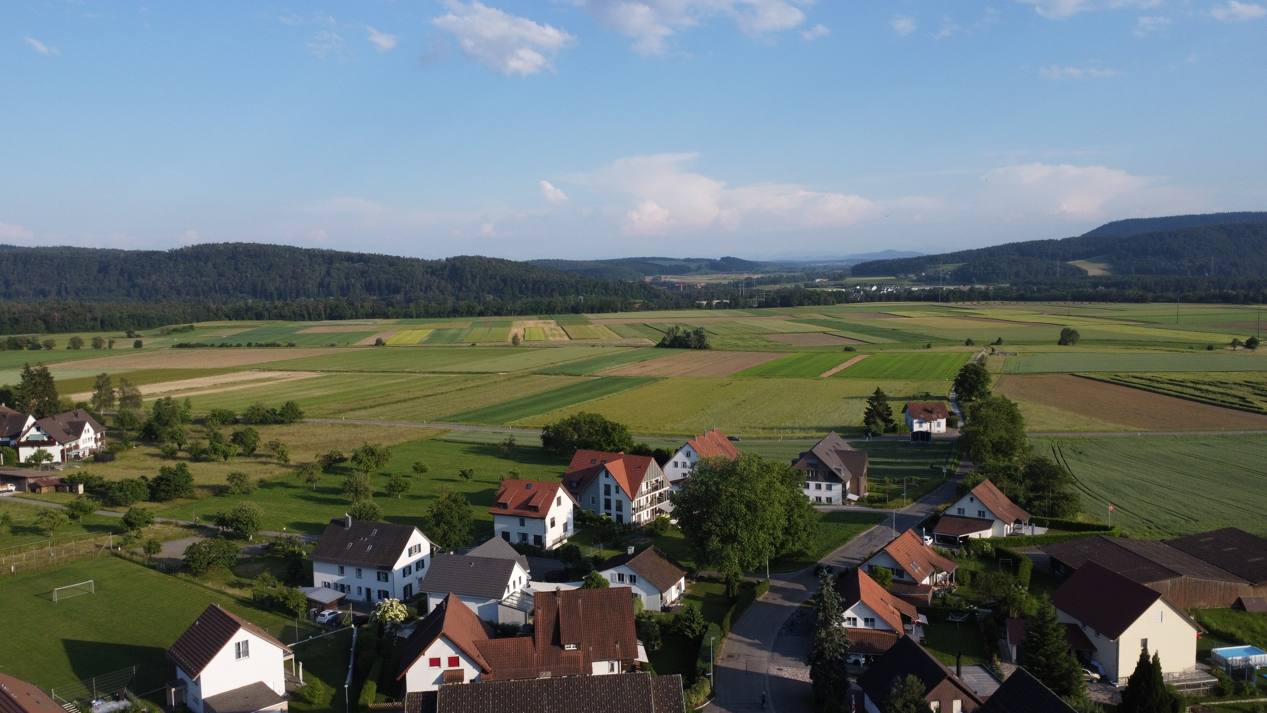 Luftaufnahme eines ländlichen Wohngebiets mit Feldern
