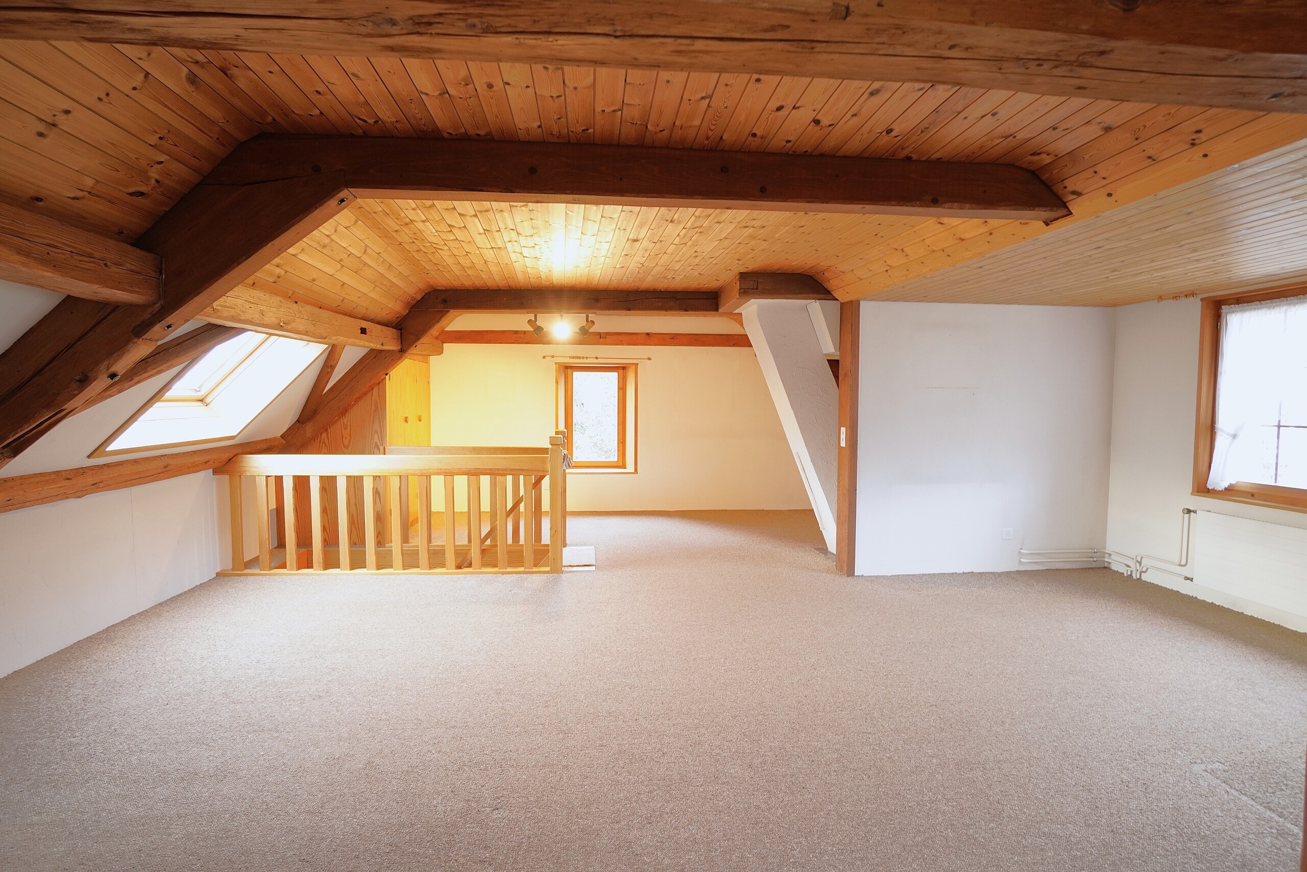 Ausgebauter Dachboden mit Holzdecke und Teppichboden
