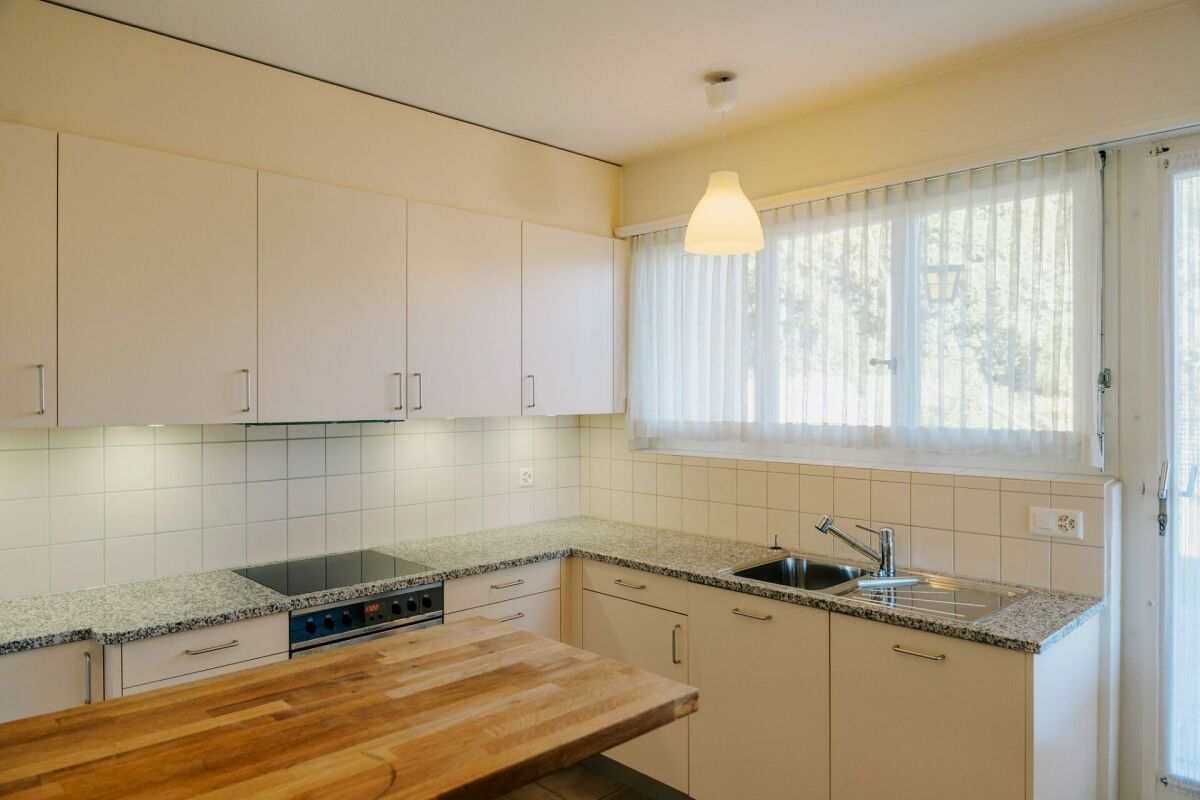 Helle Einbauküche mit Fenster und Holztresen