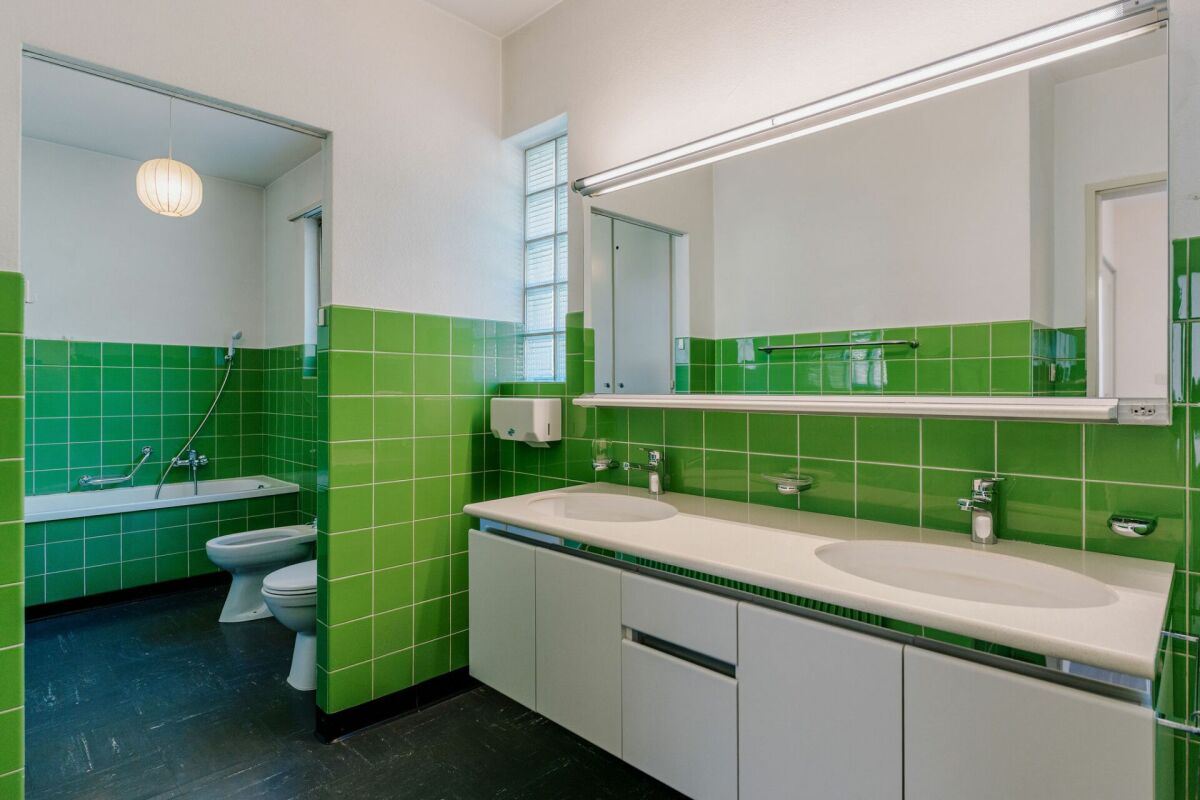 Badezimmer mit grünen Fliesen und Doppelwaschtisch