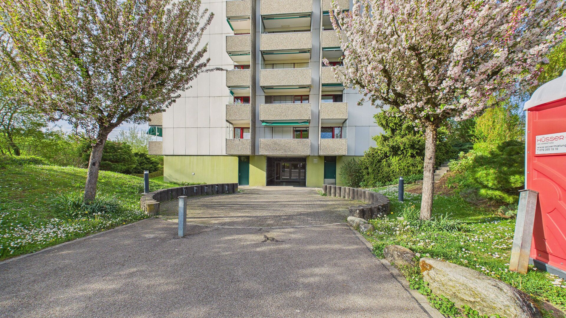 Wohnhaus mit Balkonanlage und begrüntem Eingangsbereich
