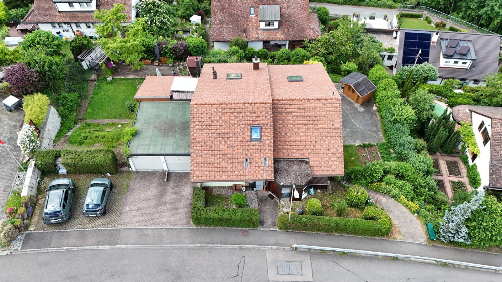 Luftaufnahme eines Einfamilienhauses mit Garten und Zufahrt