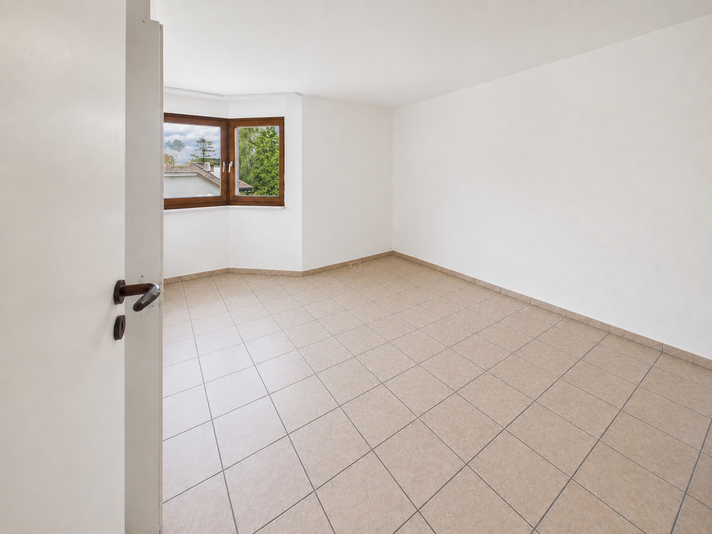 Leerer heller Raum mit Fliesenboden und Fenster