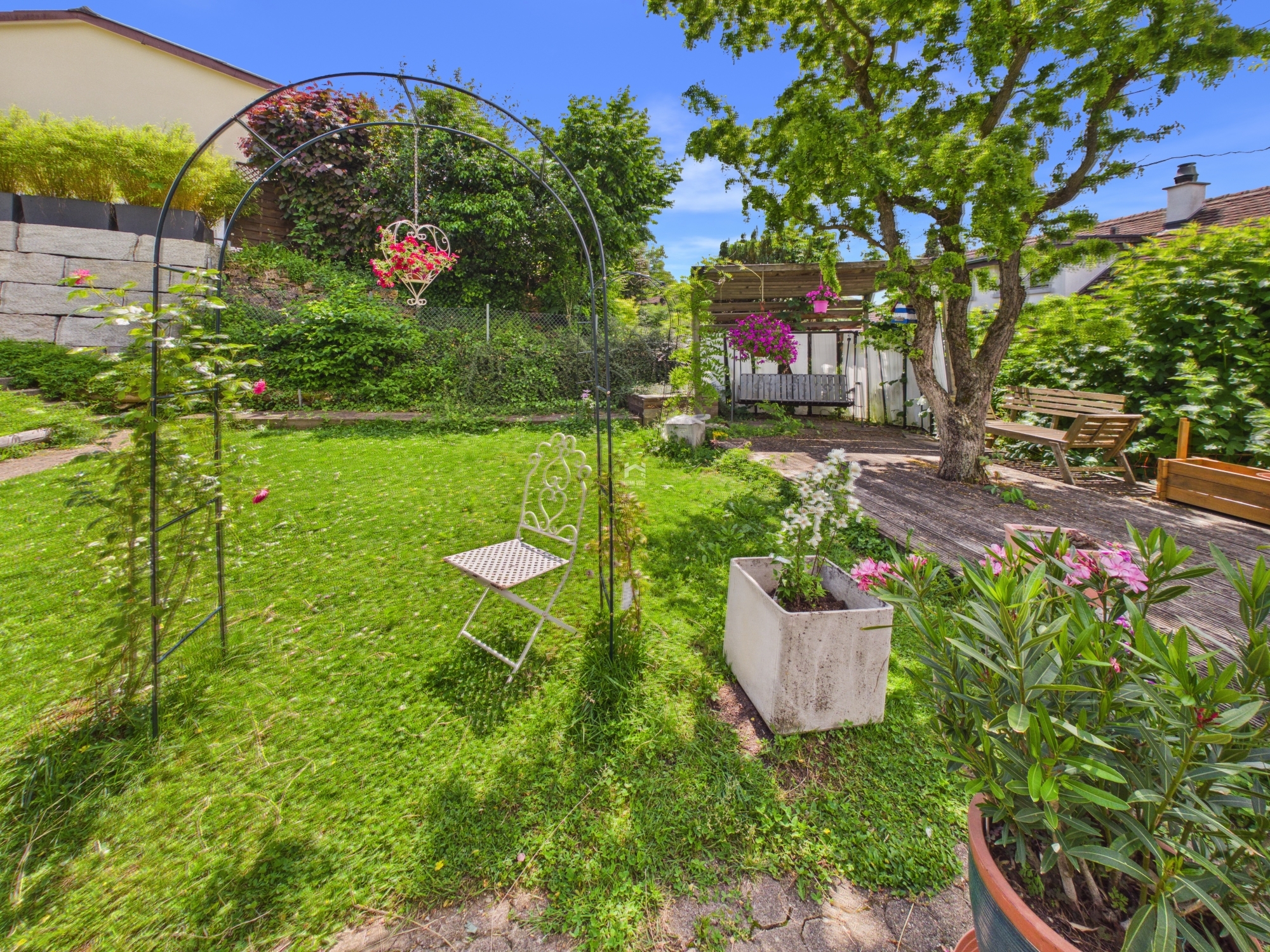 Grüner Garten mit Sitzplätzen und Pergola