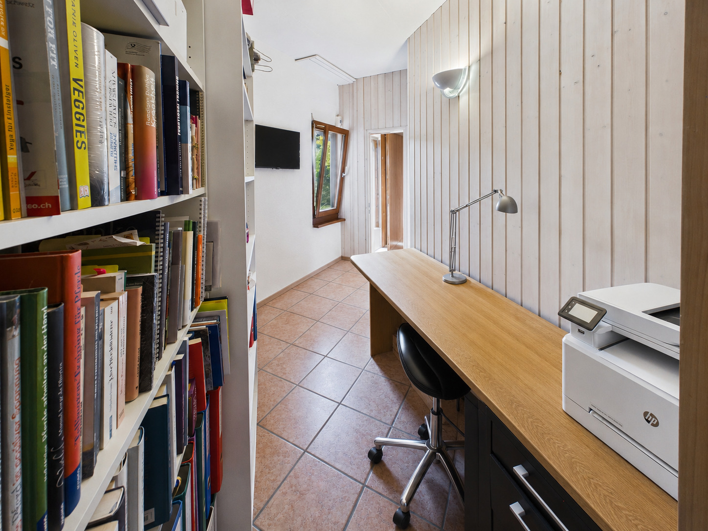 Schmaler Arbeits- und Abstellraum mit Schreibtisch