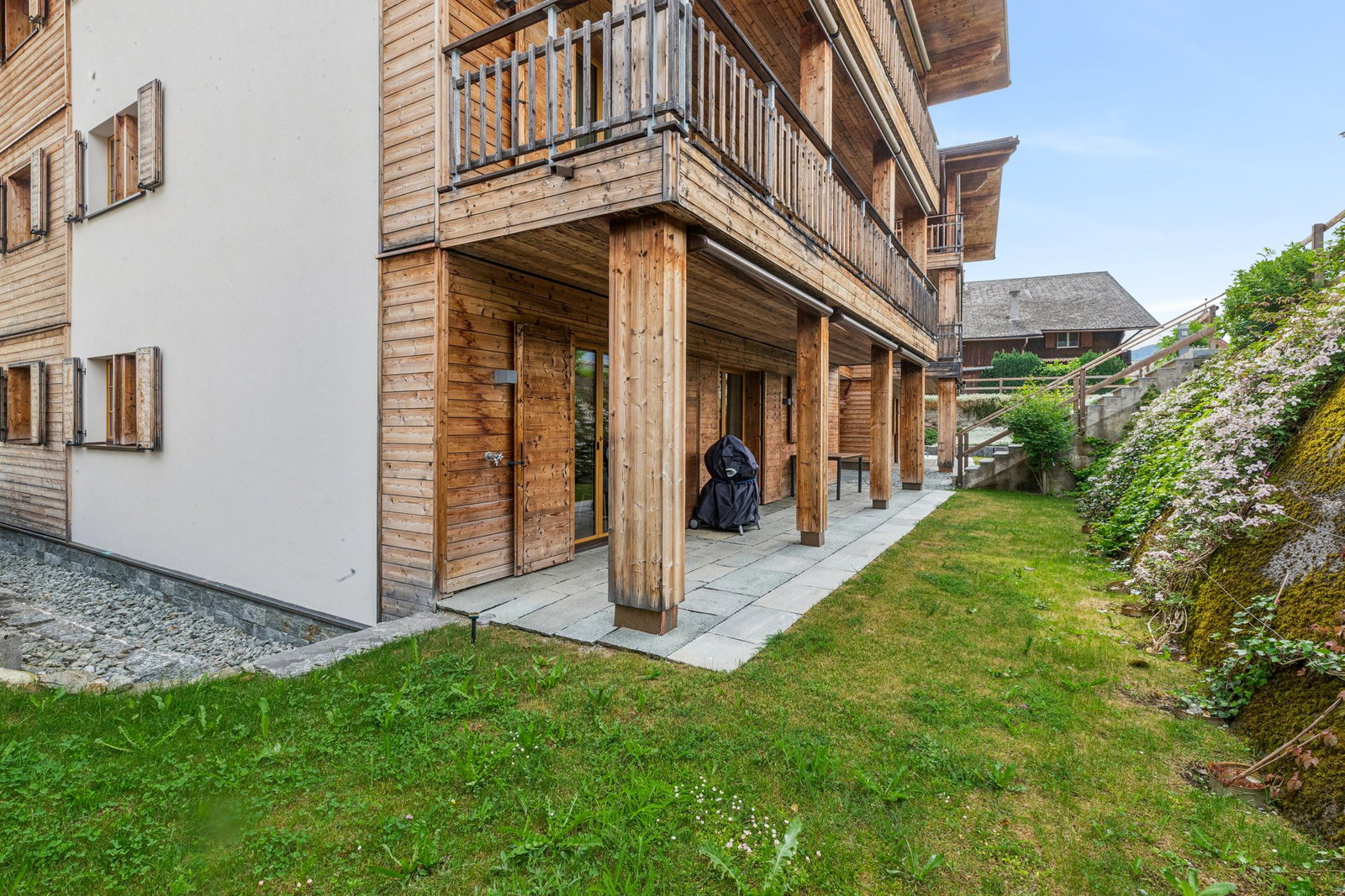 Außenansicht eines Holzchalets mit Garten und Balkon