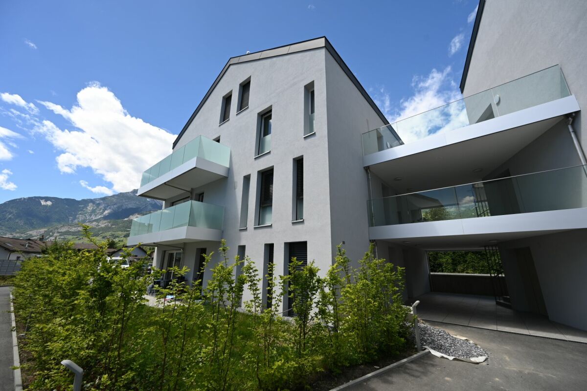 Modernes Mehrfamilienhaus mit Balkonen und Bergblick
