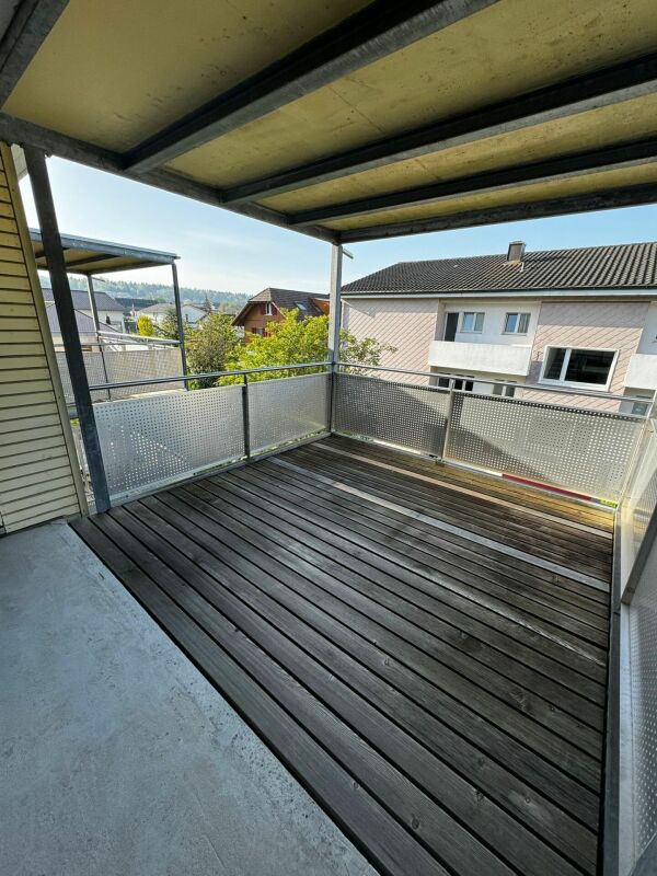 Balkon mit Holzdeck und Metallgeländer