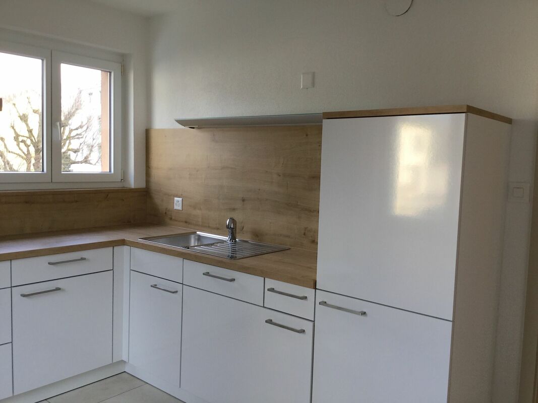Helle Einbauküche mit Weißfronten und Holzoptik