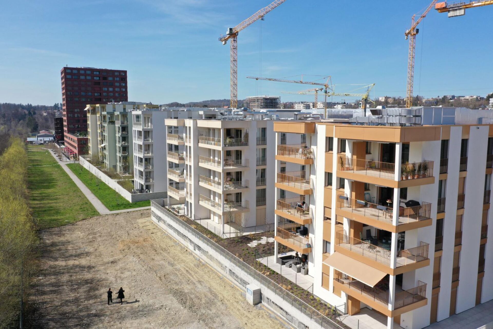 Luftaufnahme eines modernen Wohnquartiers mit Neubauten und Kränen