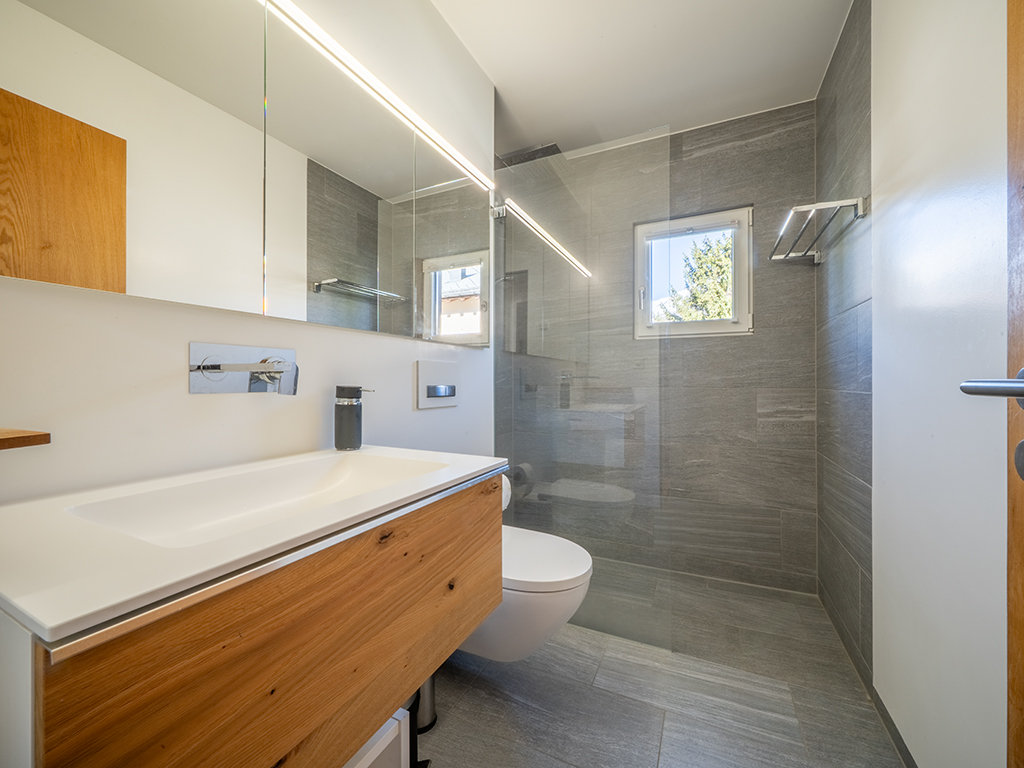Modernes Badezimmer mit Dusche und Holzwaschtisch