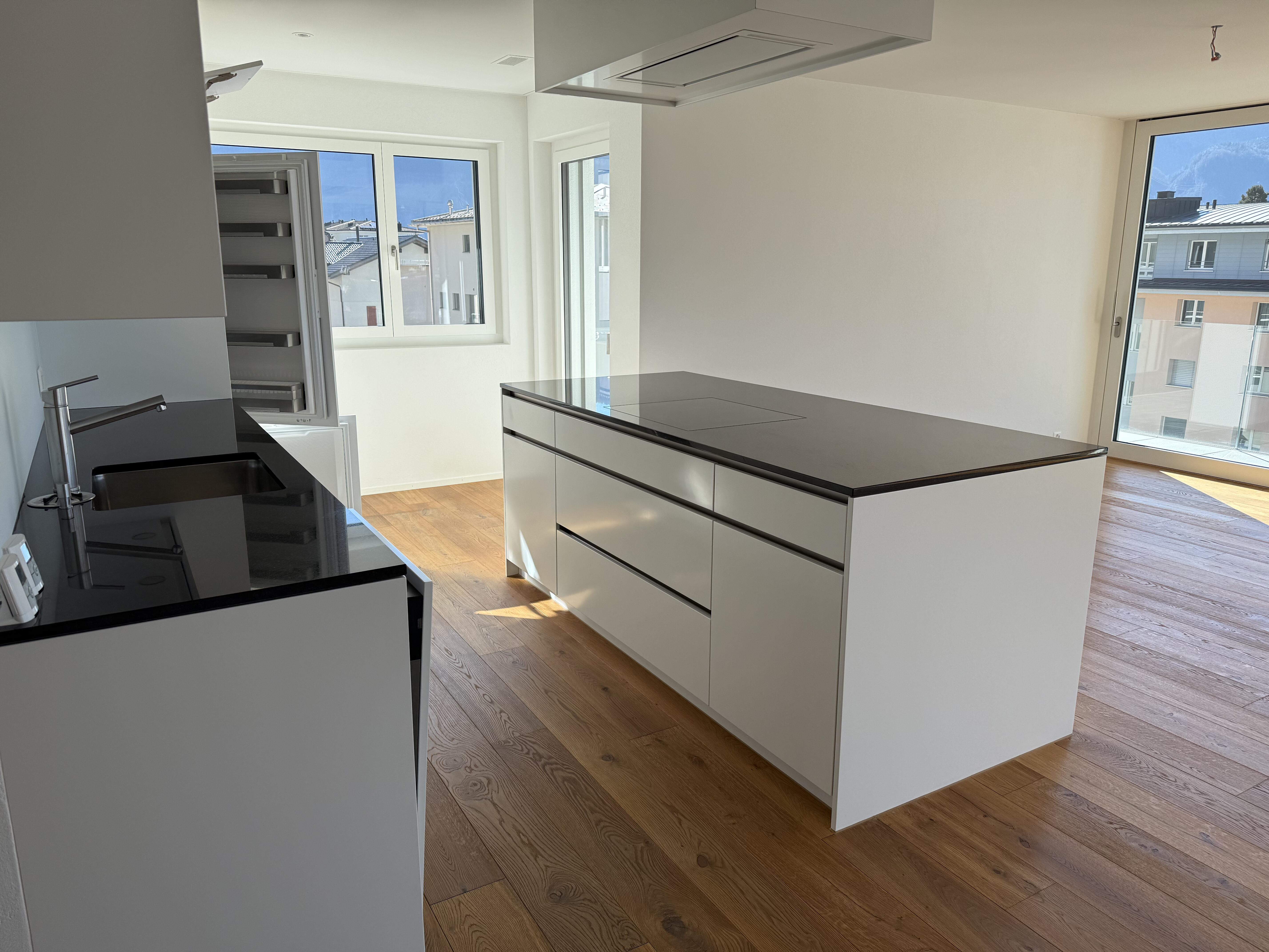 Moderne Küche mit Kochinsel und großem Tageslicht