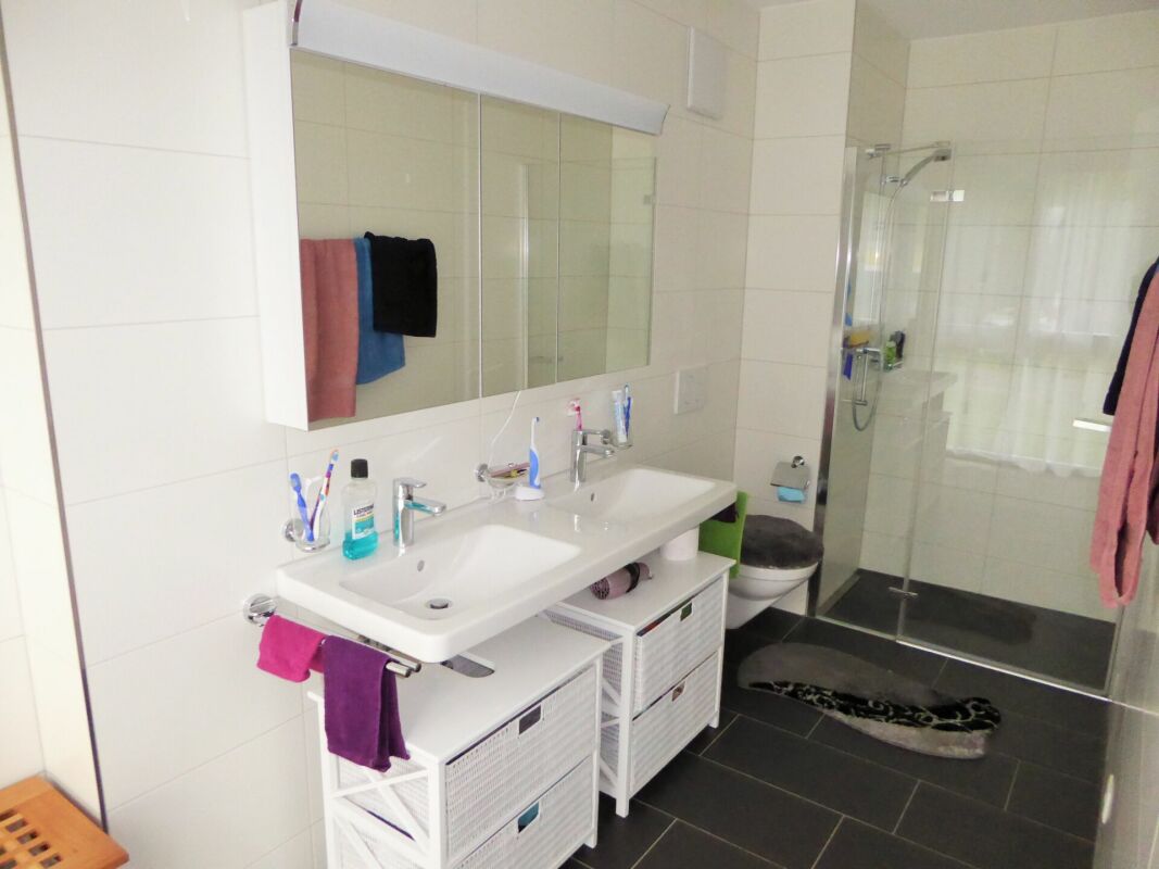 Modernes Badezimmer mit Doppelwaschbecken und Glasdusche