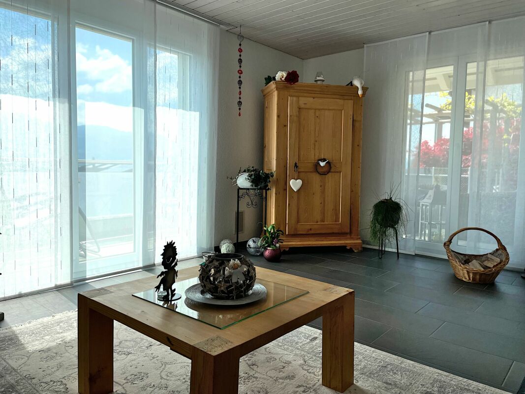 Heller Wohnraum mit großen Fensterfronten und Holzmöbeln