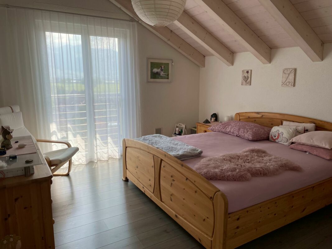 Helles Schlafzimmer mit Holzbett und Dachschrägen